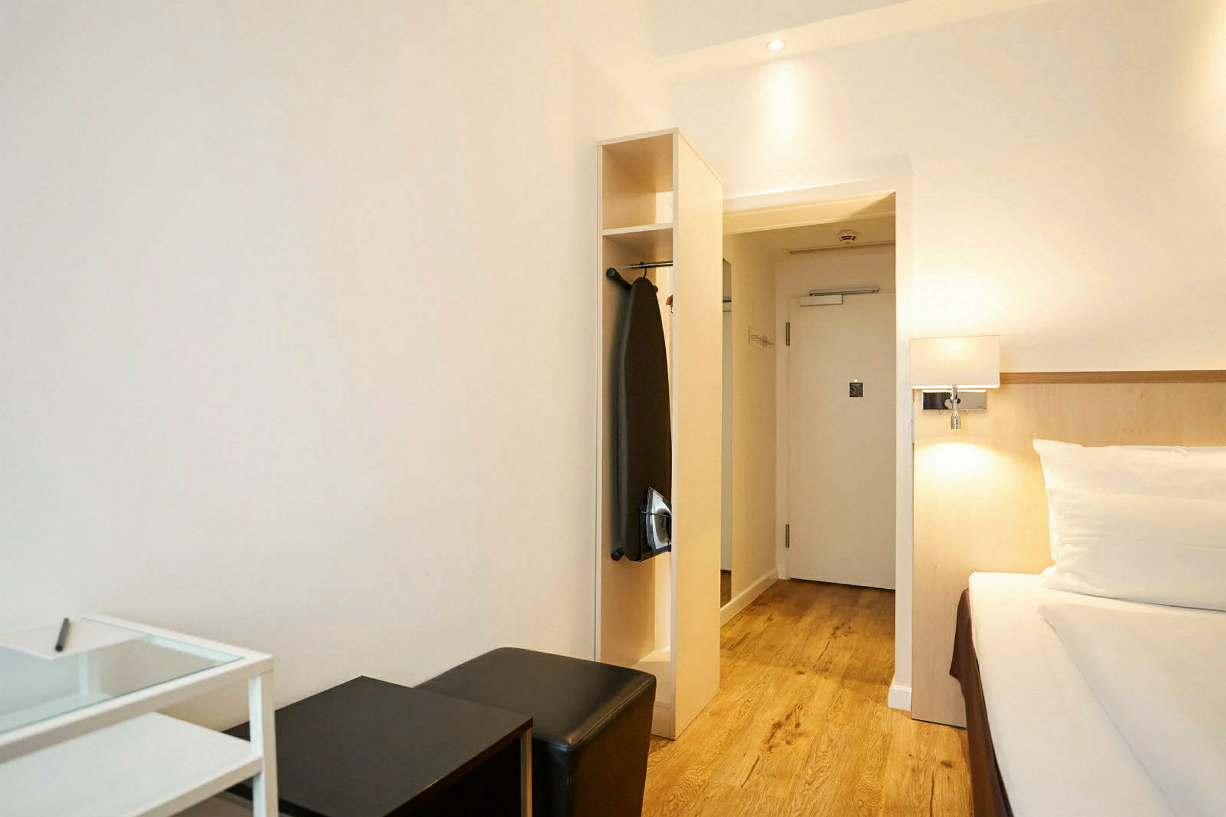 Ett hotellrum med säng, sittmöbler och garderob. (AI-genererad text)