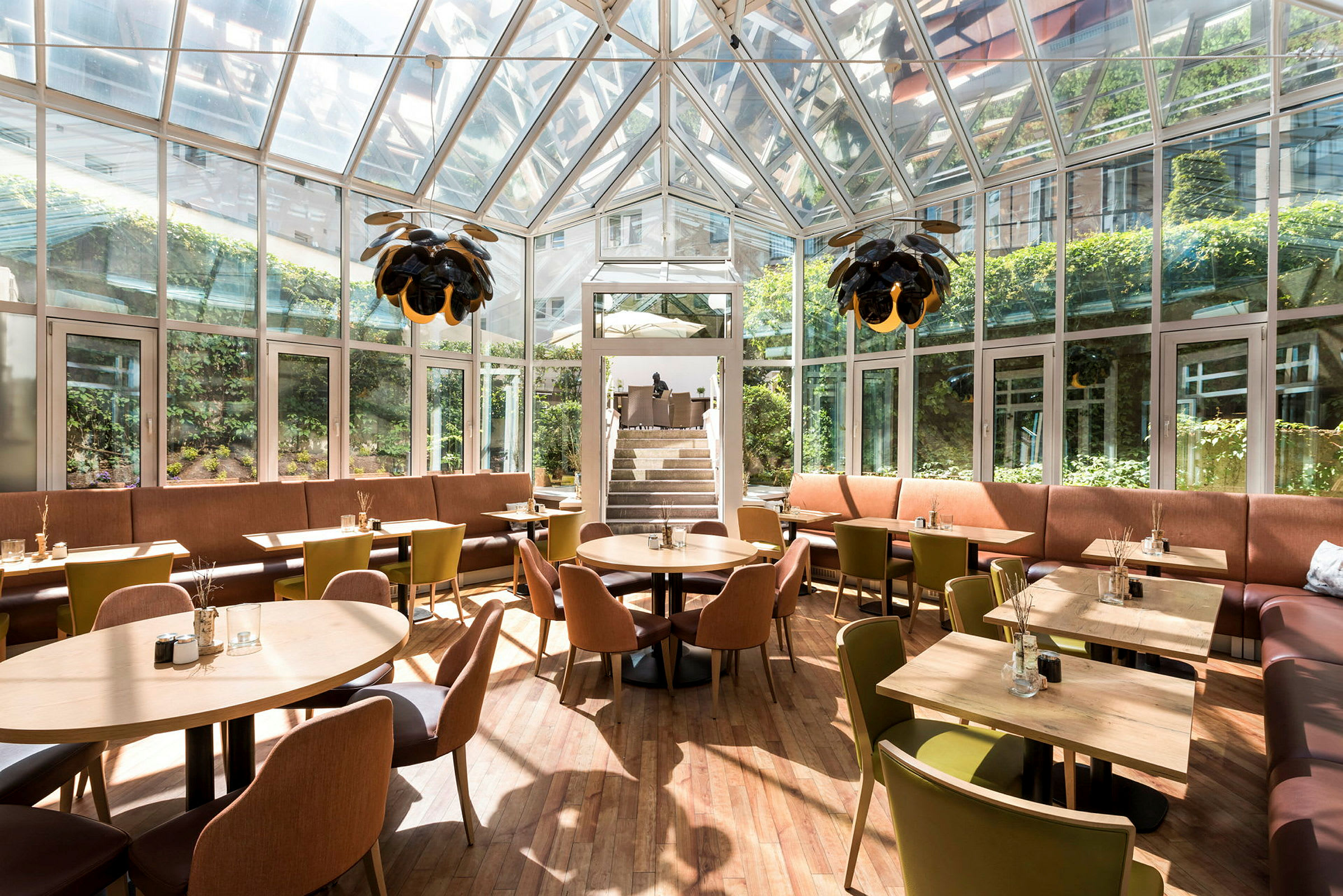 Skyddad restaurang med glasväggar, sittplatser och belysning. (AI-genererad text)