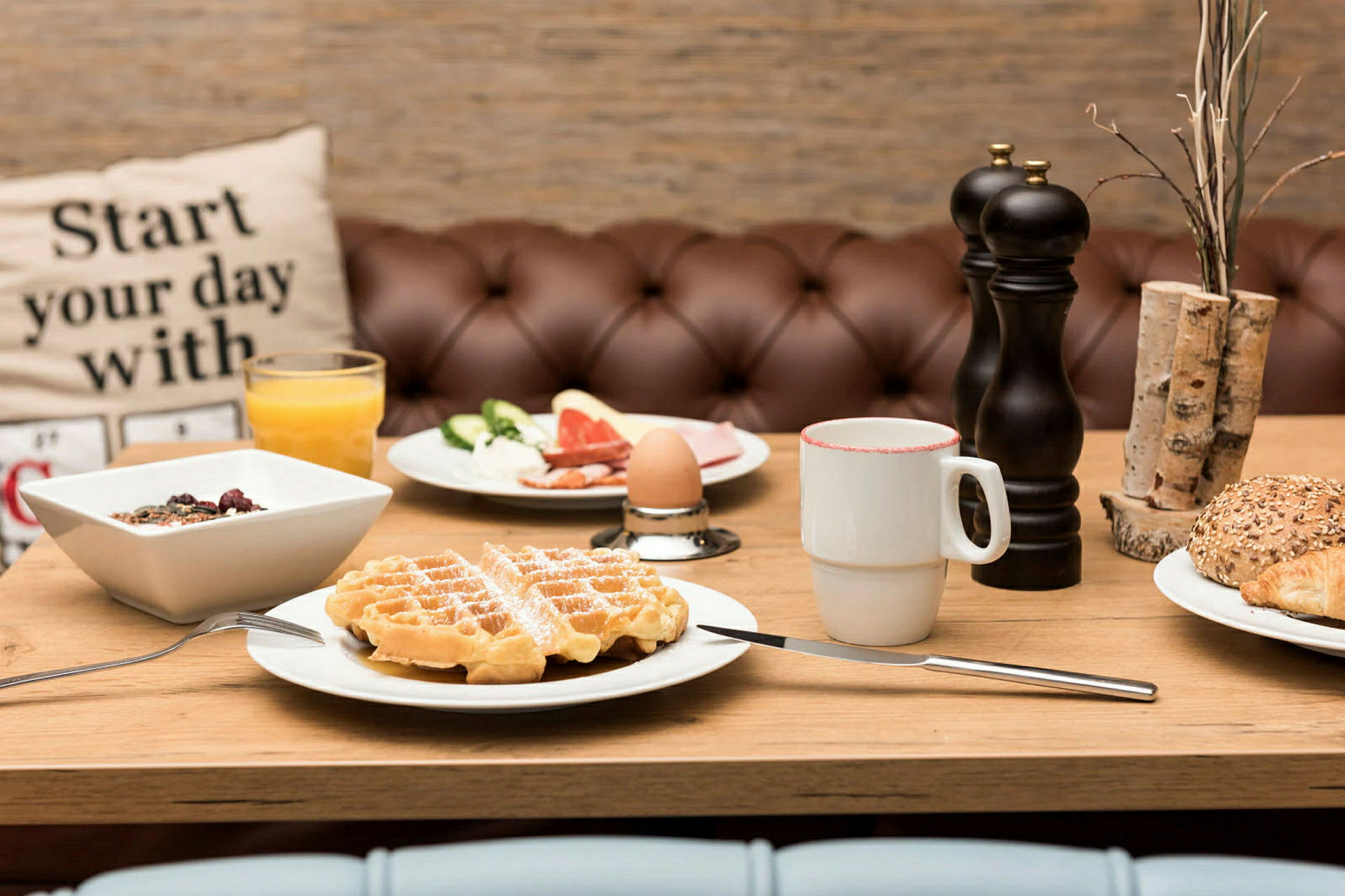 En frukostservering med våfflor, bröd, yoghurt och kaffe. (AI-genererad text)