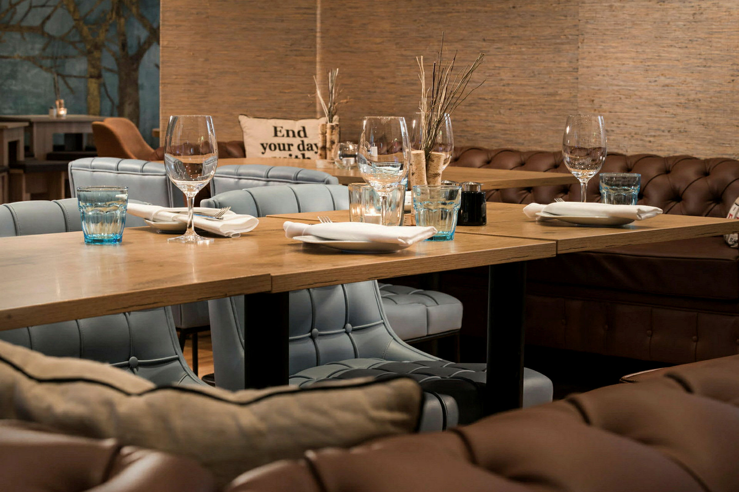 En restauranginteriör med dukat bord och klädda stolar. (AI-genererad text)