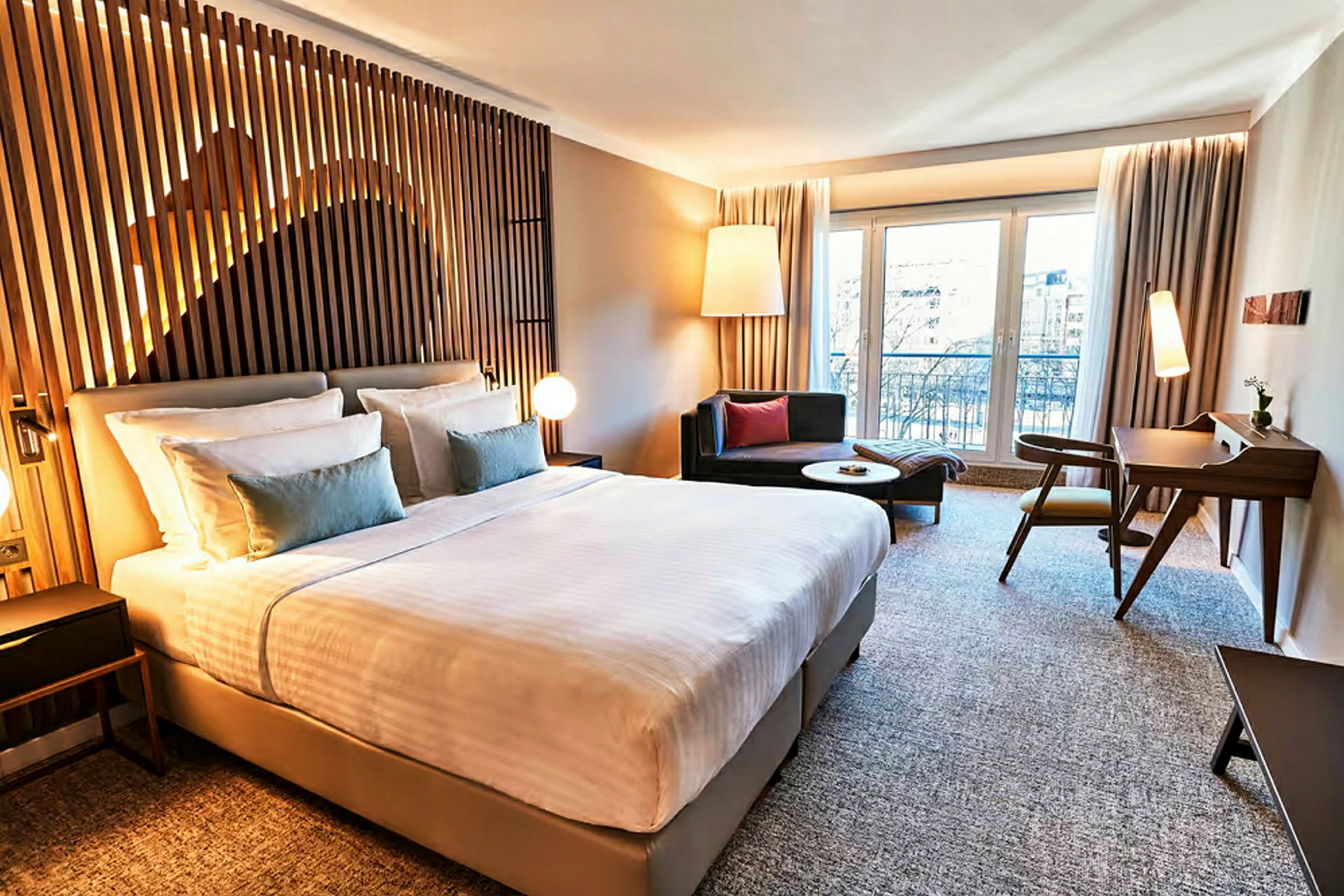 Ett modernt hotellrum med en stor säng, sittmöbler och skrivbord. (AI-genererad text)