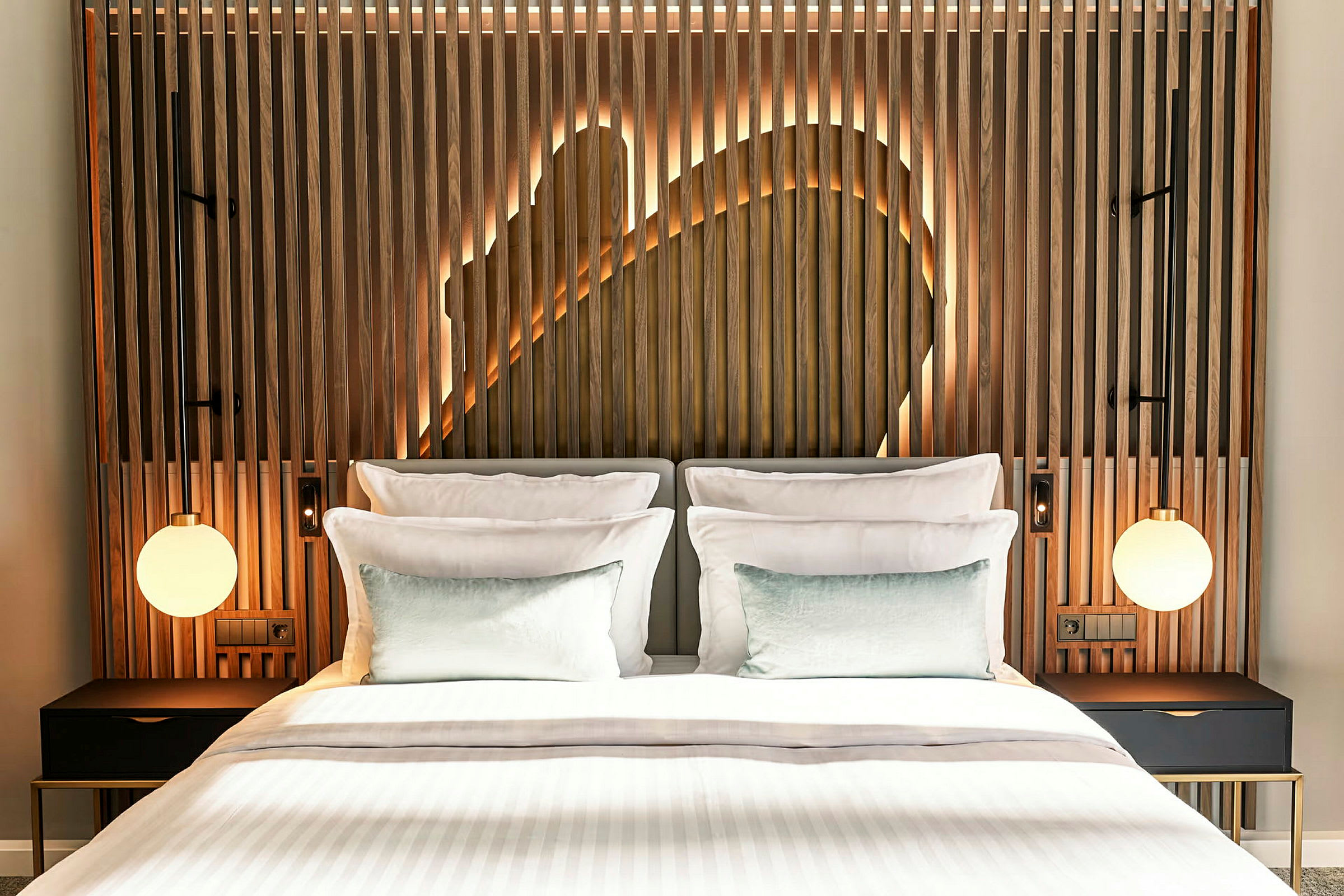 En modern hotellsäng med vita sängkläder och trädetaljer bakom i huvudgaveln, belyst med dekorativ bakgrundsbelysning. (AI-genererad text)