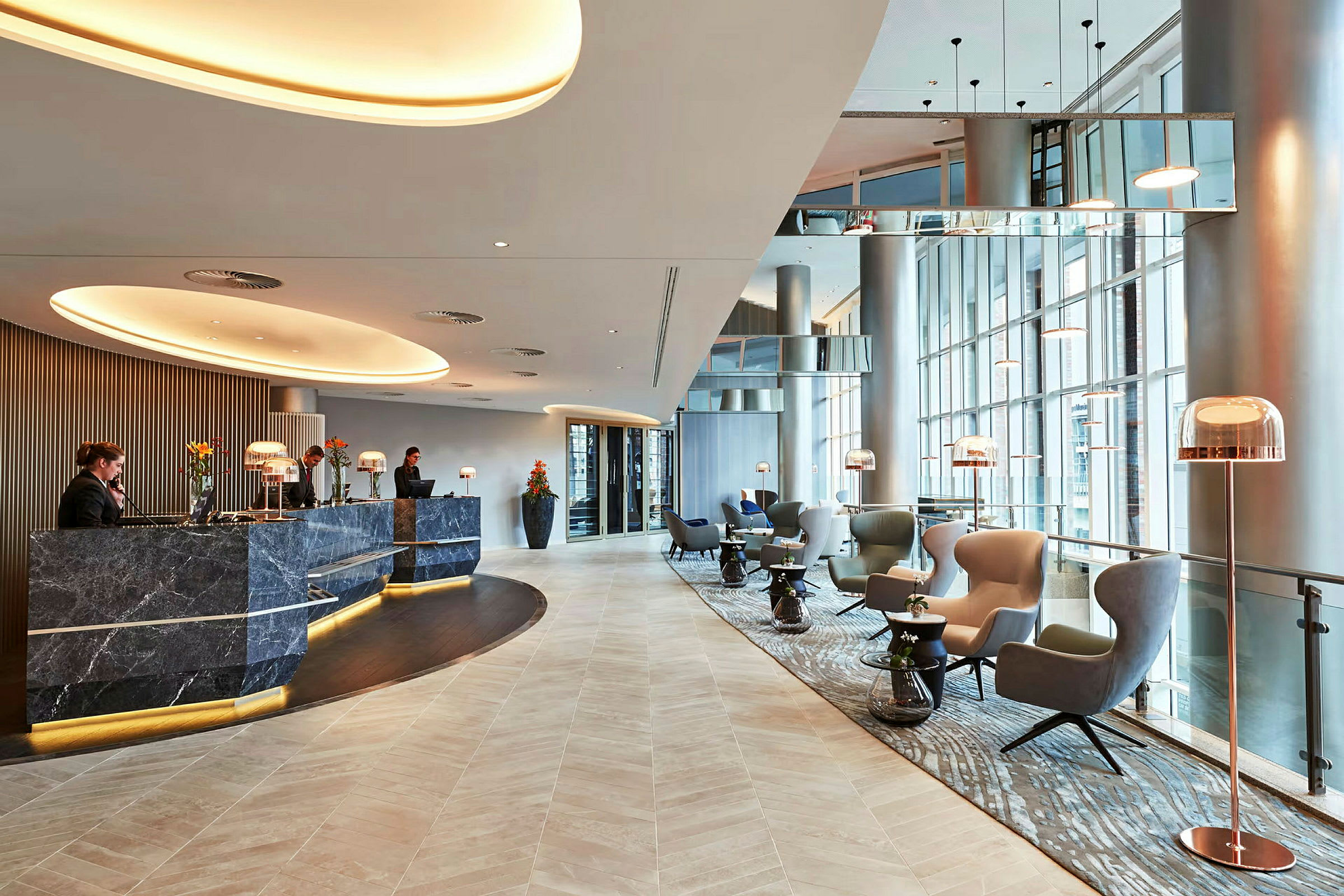En modern hotellobby med reception och sittgrupper. (AI-genererad text)