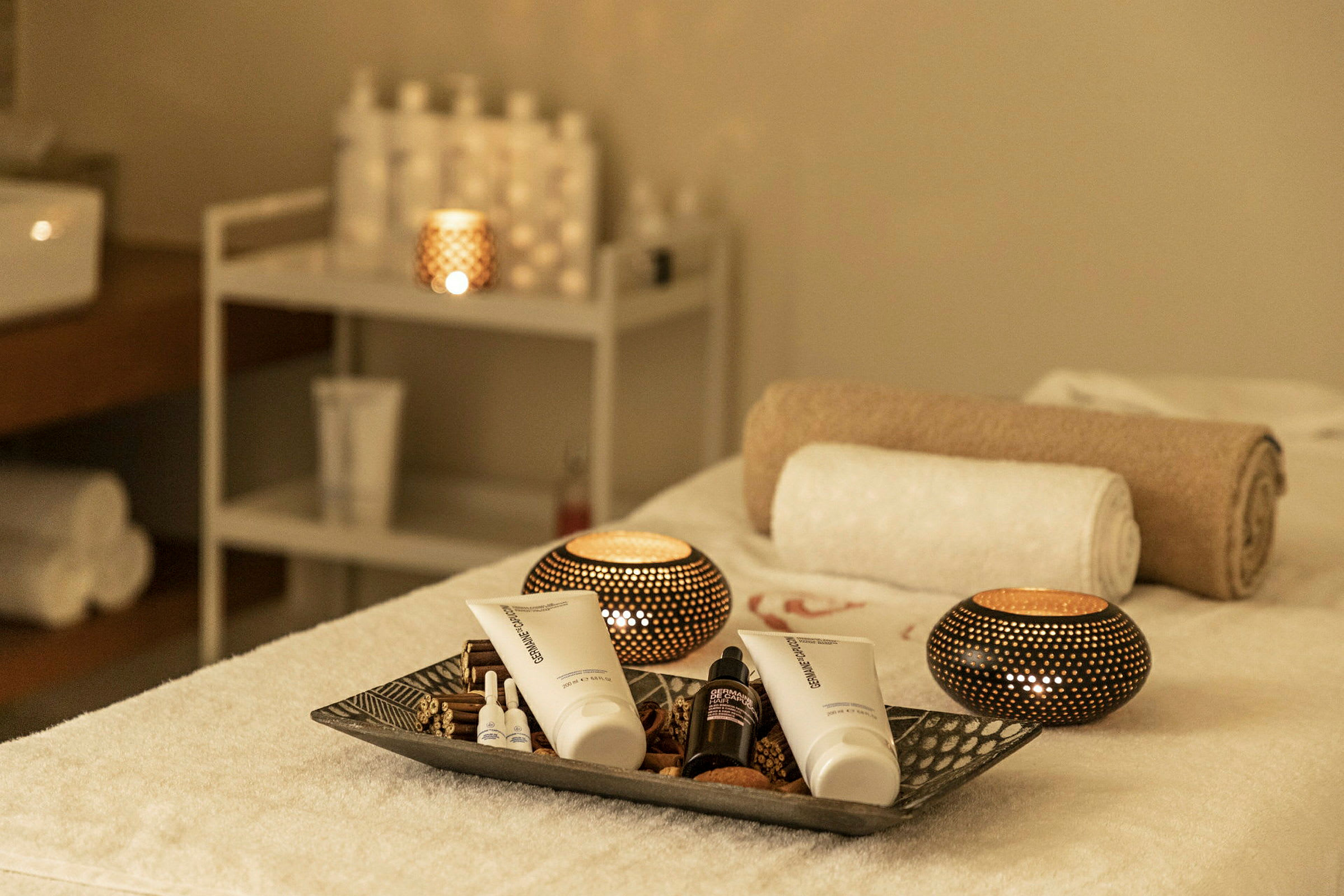 En spa-miljö med handdukar, hudvårdsprodukter och ljus. (AI-genererad text)
