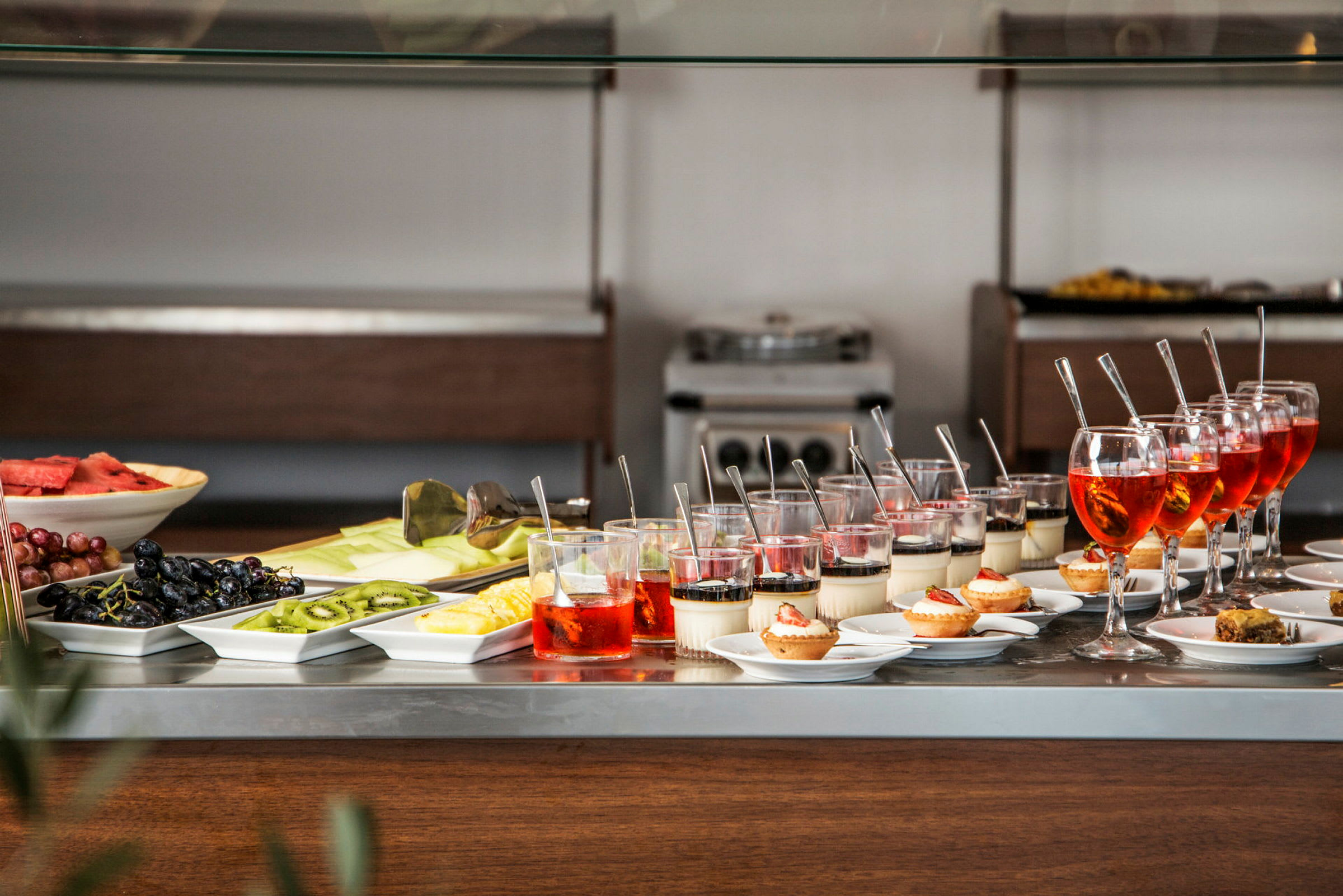 Ett buffébord med olika desserter, frukter och drycker. (AI-genererad text)