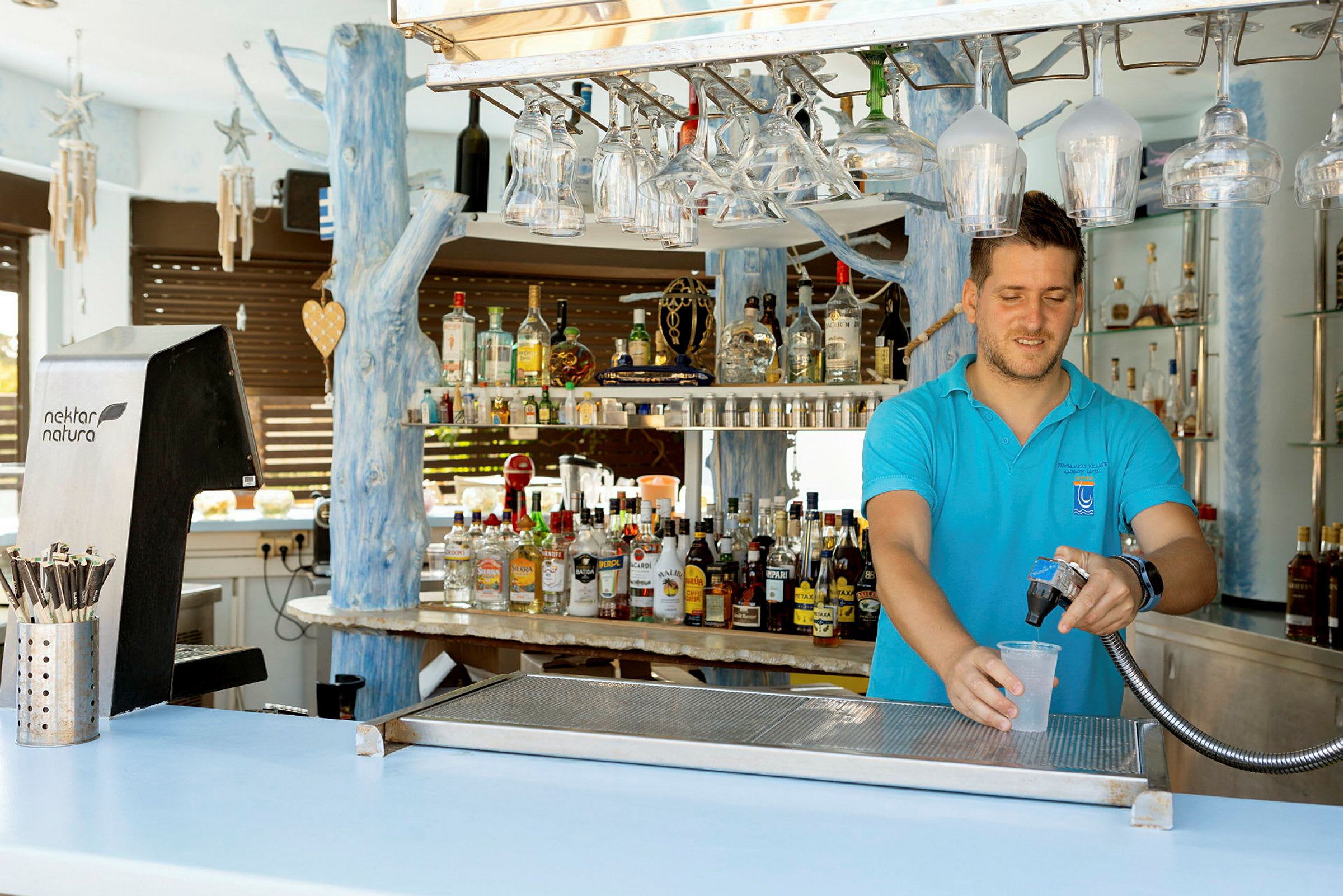 En bartender fyller ett glas med en dryck vid en bar. (AI-genererad text)