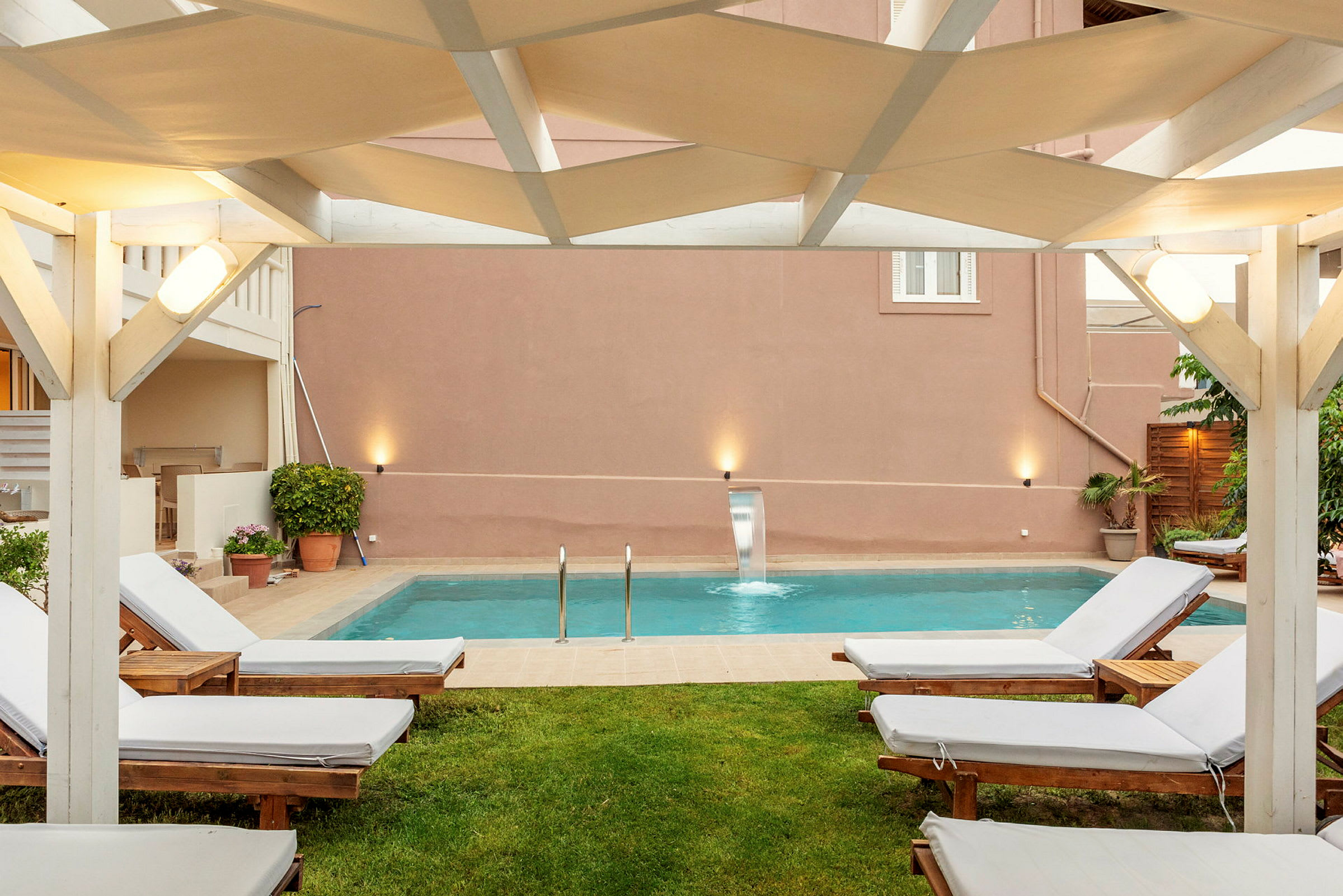 Utomhus sittområde med solstolar och en pool. (AI-genererad text)