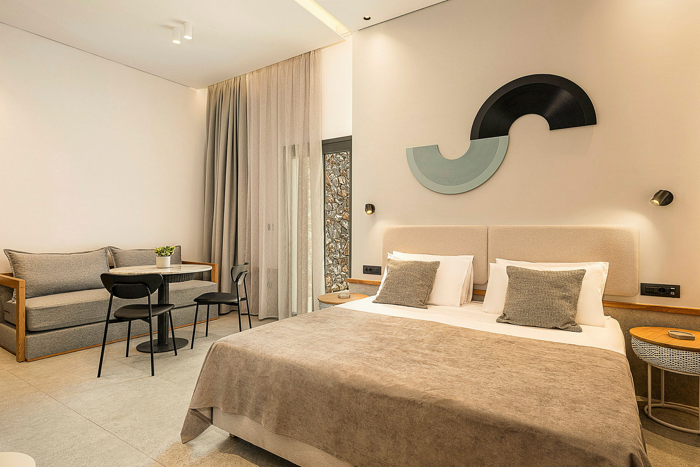 Modernt hotellrum med en dubbelsäng, sittgrupp och dekorativa detaljer. (AI-genererad text)