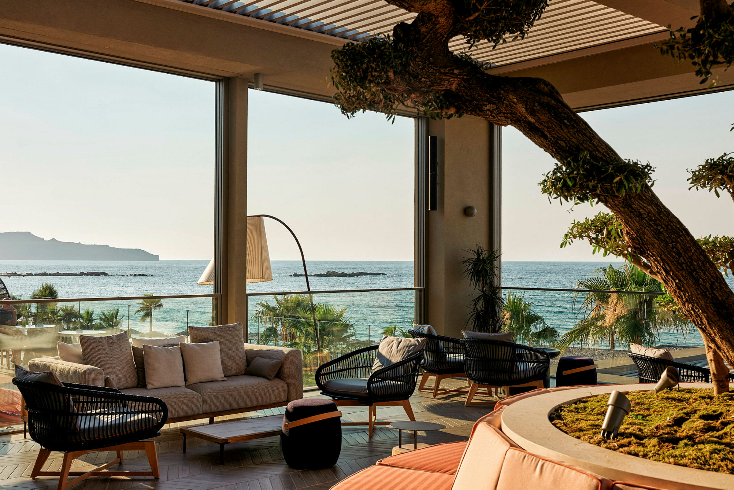 Utsikt över en möblerad lounge med havet i bakgrunden. (AI-genererad text)