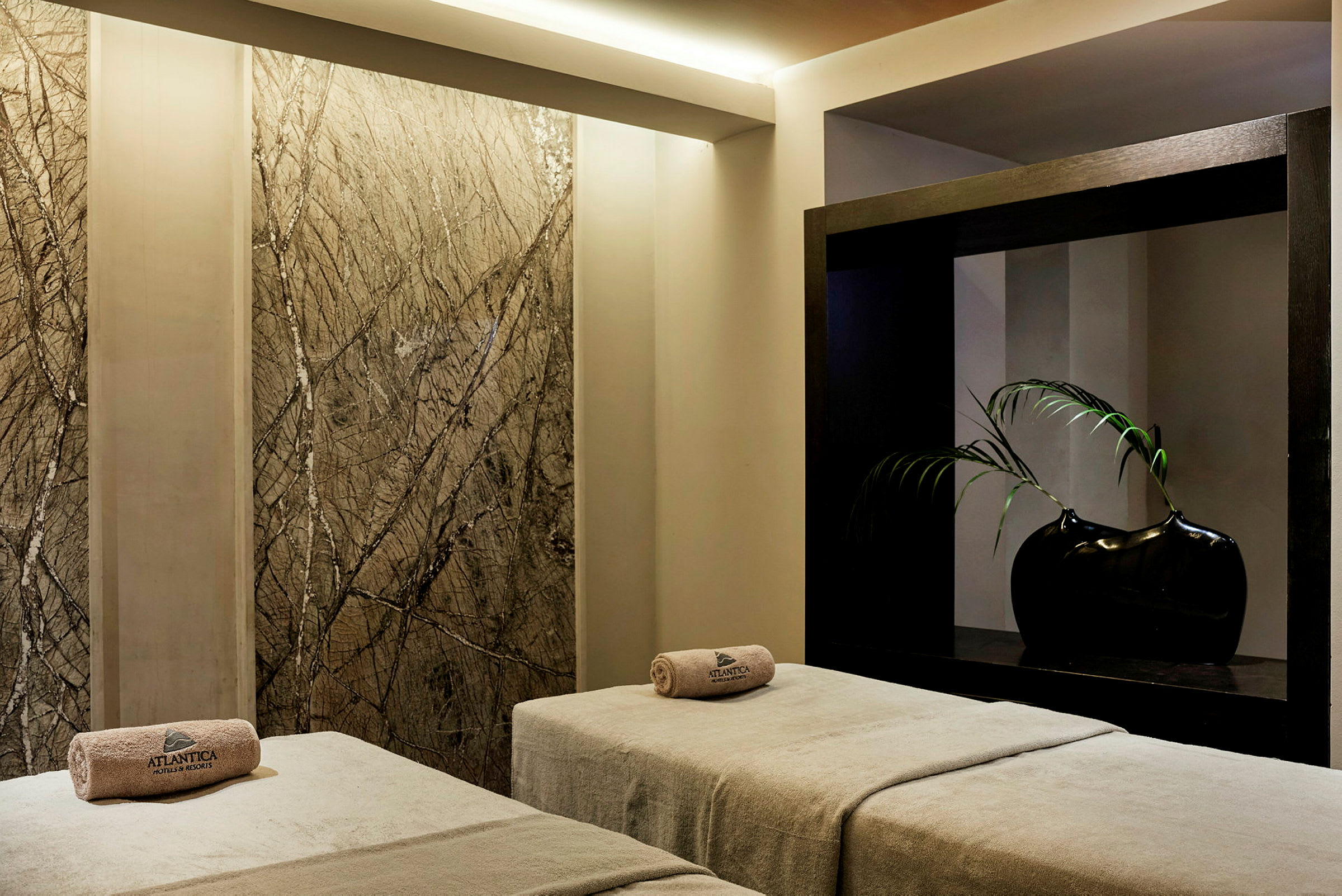 Två massagesängar med handdukar placerade på dem i en spaavdelning. (AI-genererad text)
