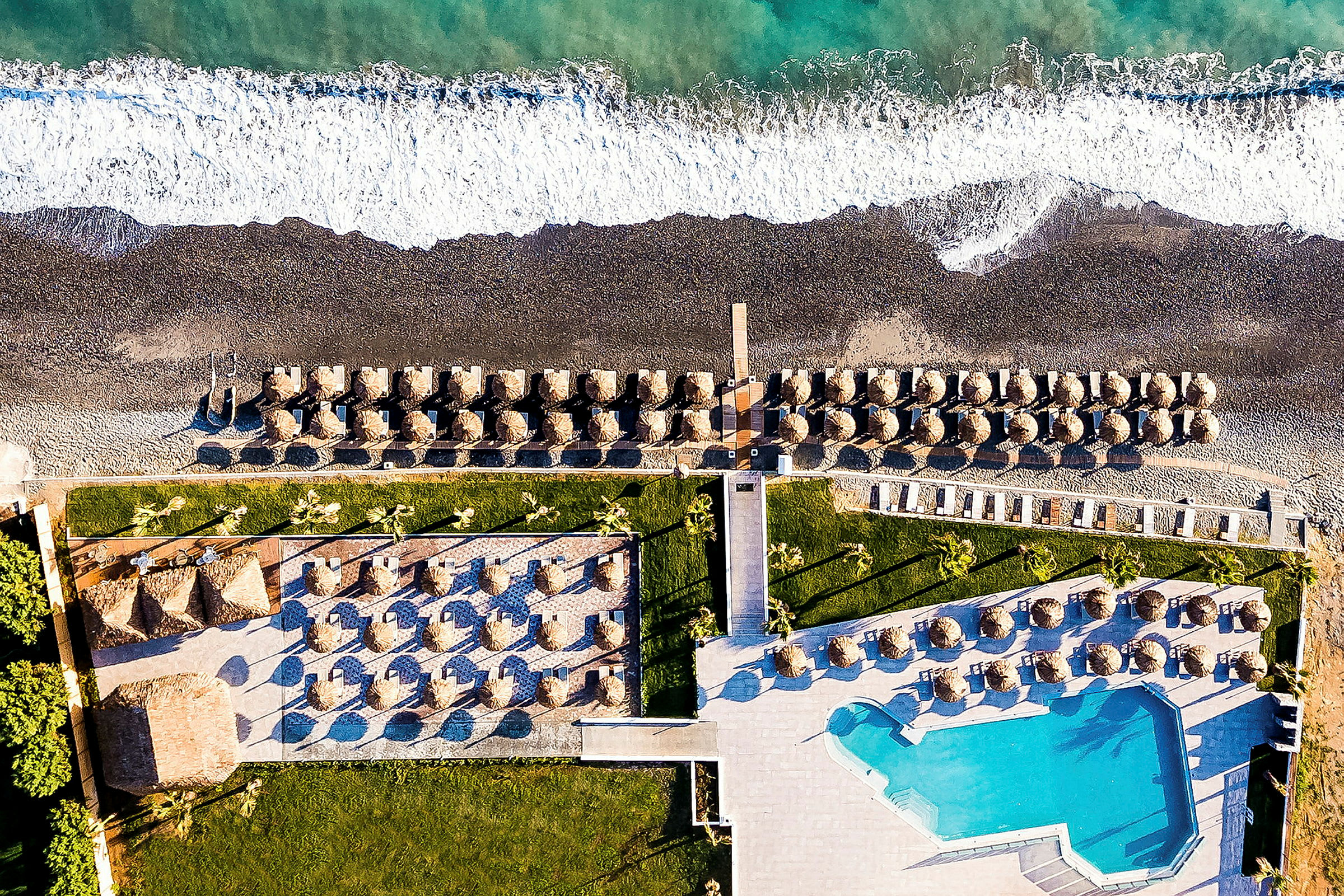 Flygfoto över en strand med parasoller och en pool. (AI-genererad text)