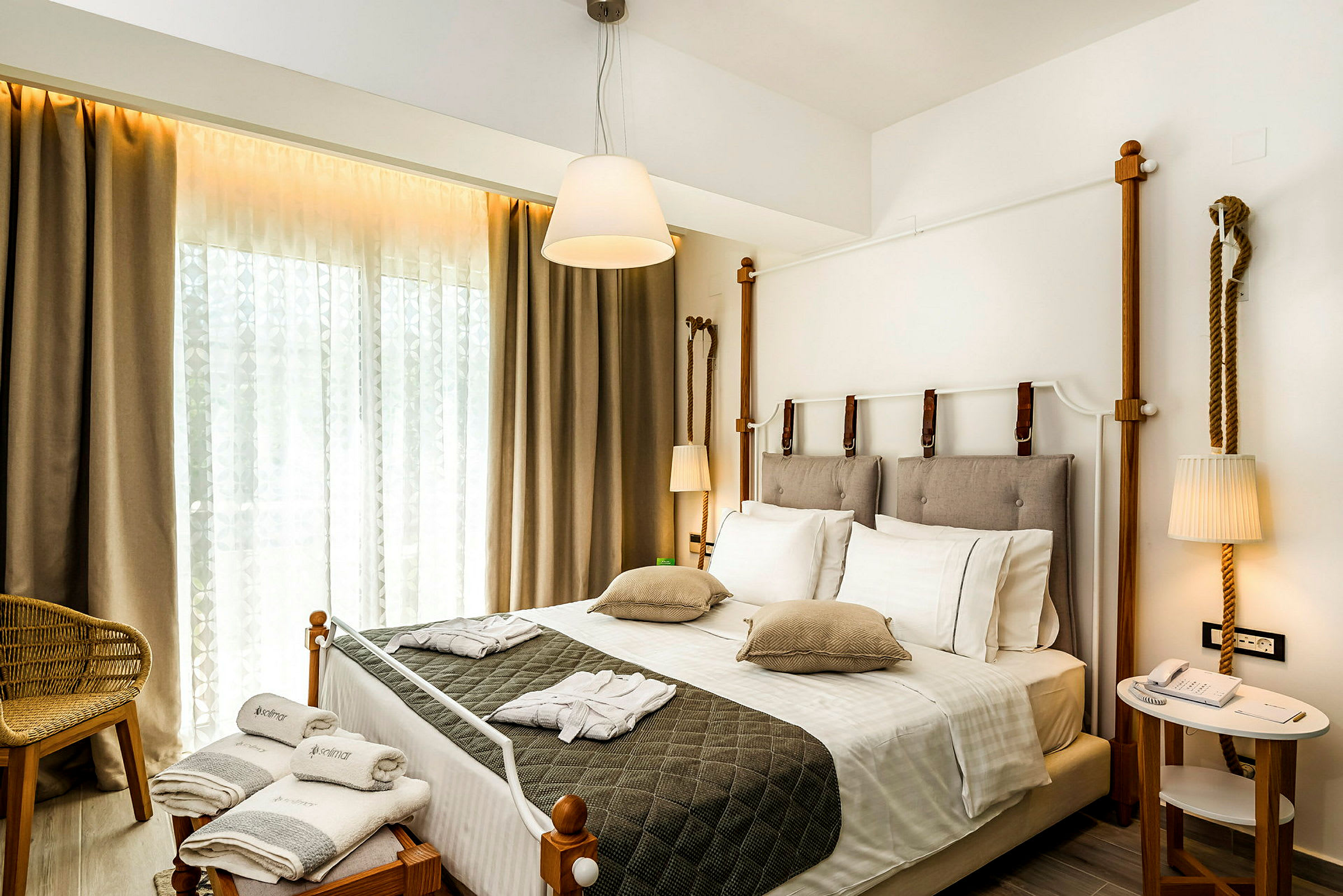 Hotellrum med dubbelsäng, sittmöbel och dekorativ belysning. (AI-genererad text)