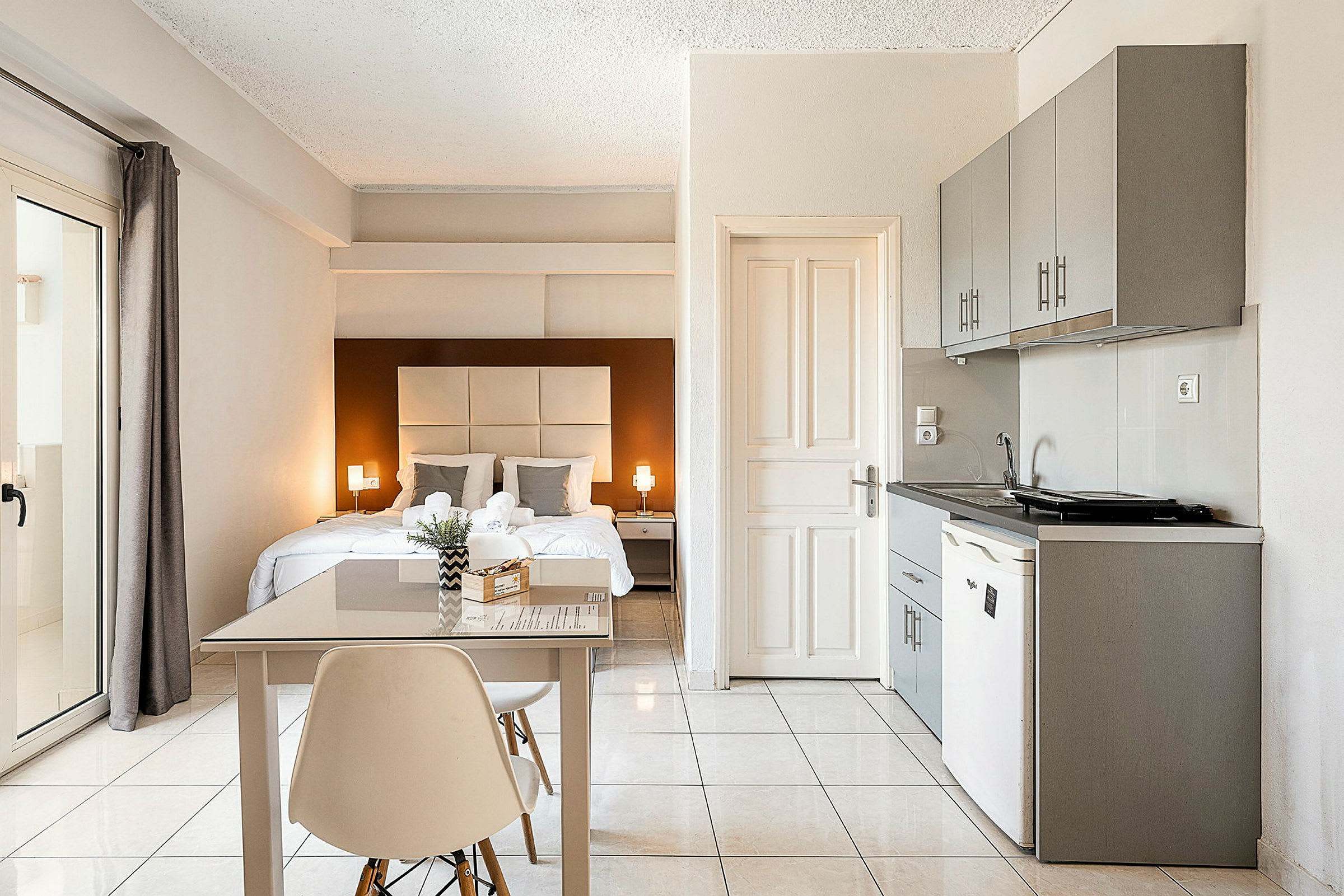 Ett ljust och modernt hotellrum med ett dubbelrum, ett litet matbord och en kokvrå. (AI-genererad text)