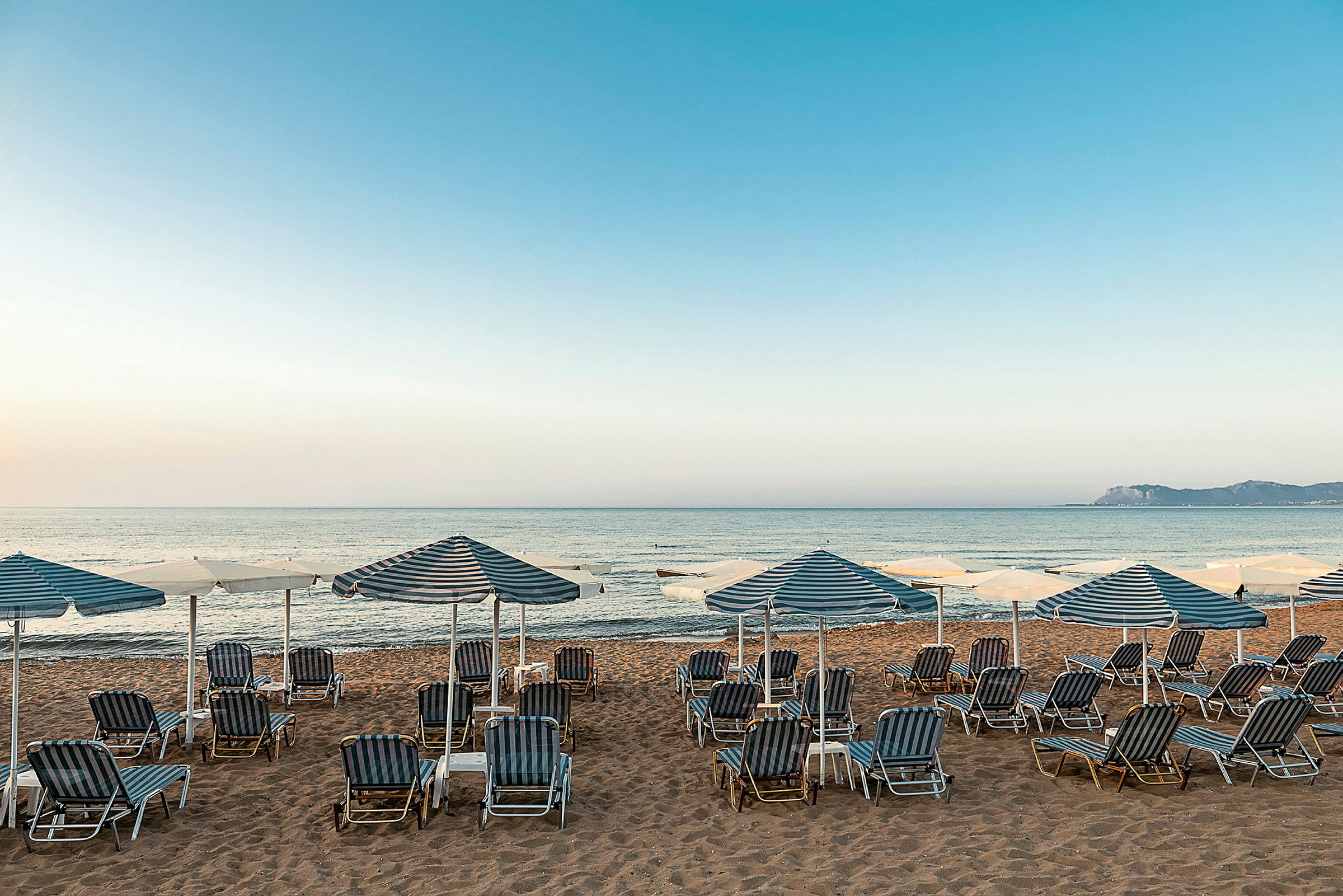 Strand med solstolar och parasoller vid havet. (AI-genererad text)