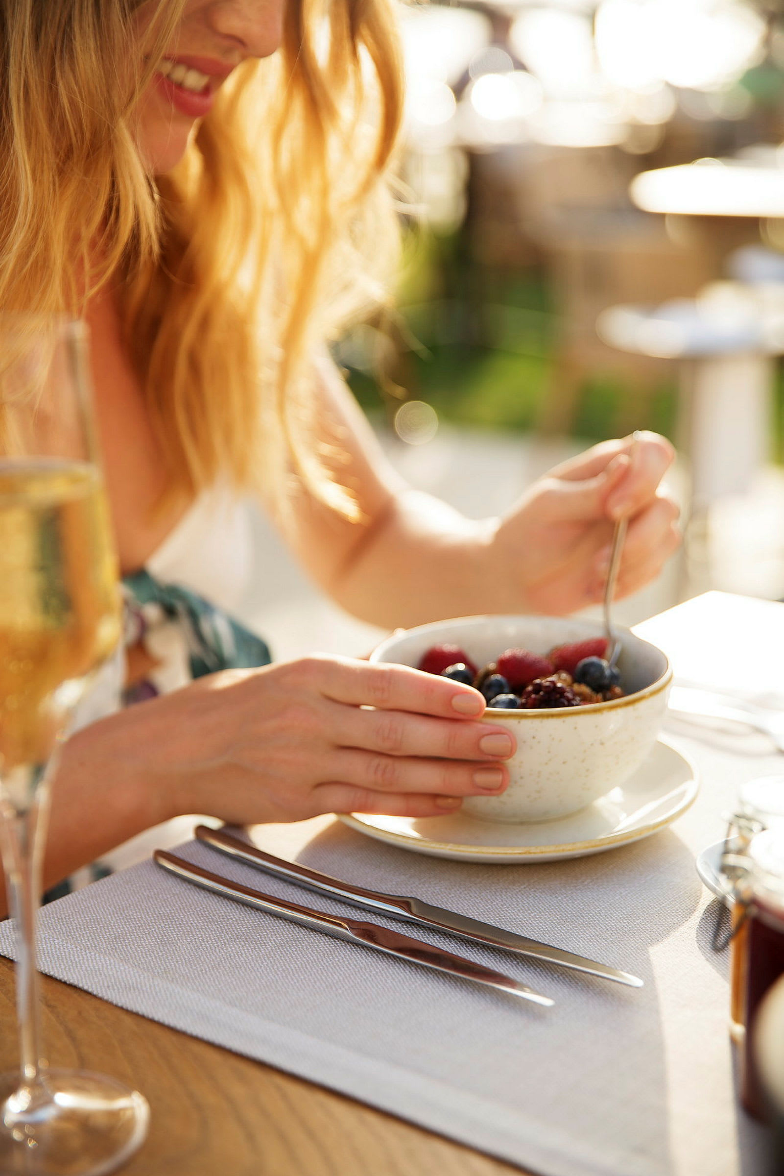 En person äter frukost med en skål granola och bär på ett bord. (AI-genererad text)