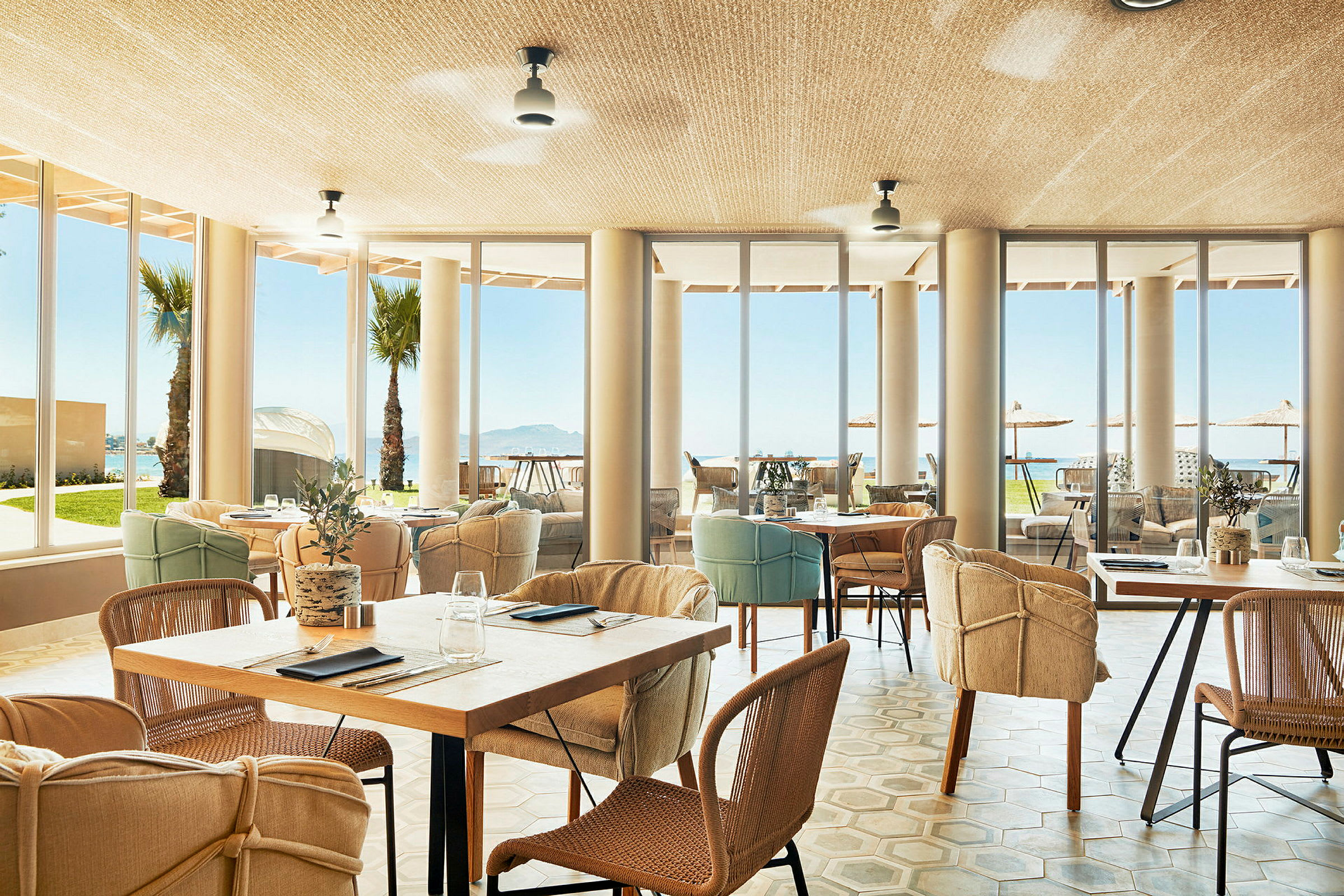 En restaurang med stora fönster och utsikt över havet. (AI-genererad text)
