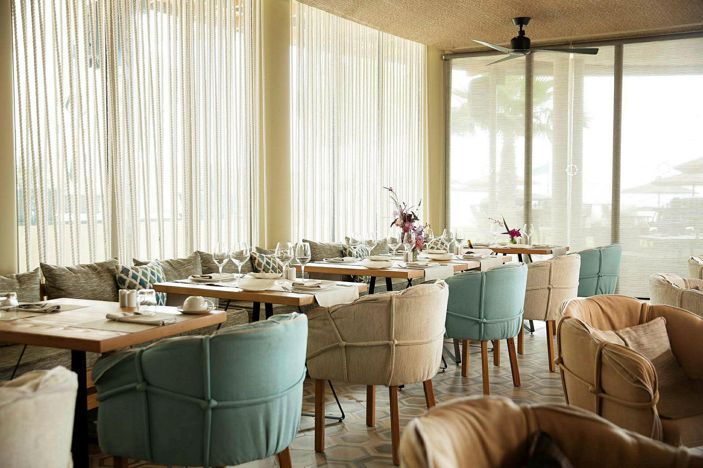 En ljus restaurang med dukade bord och bekväma stolar. (AI-genererad text)