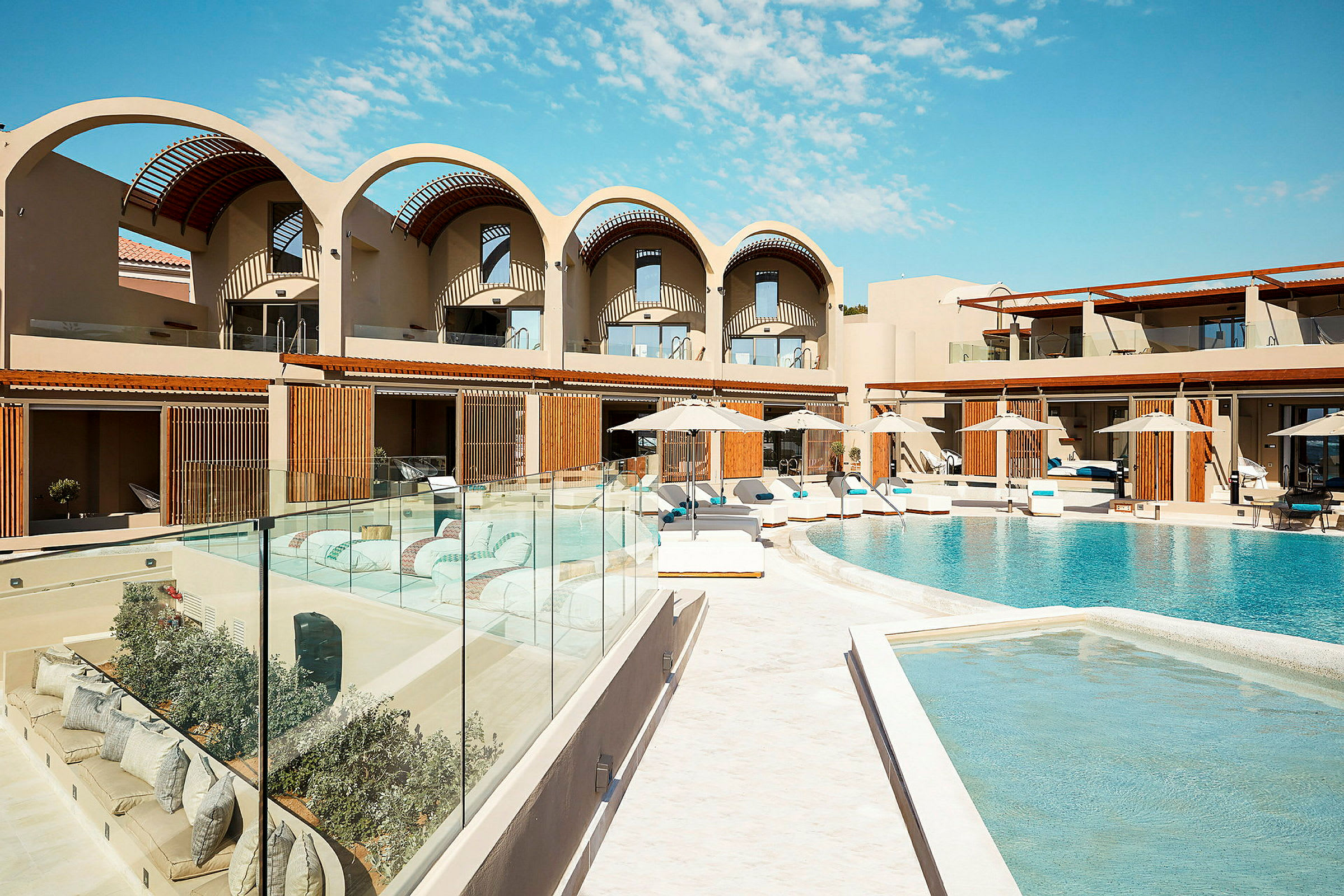 Hotellområde med swimmingpool och moderna byggnader. (AI-genererad text)