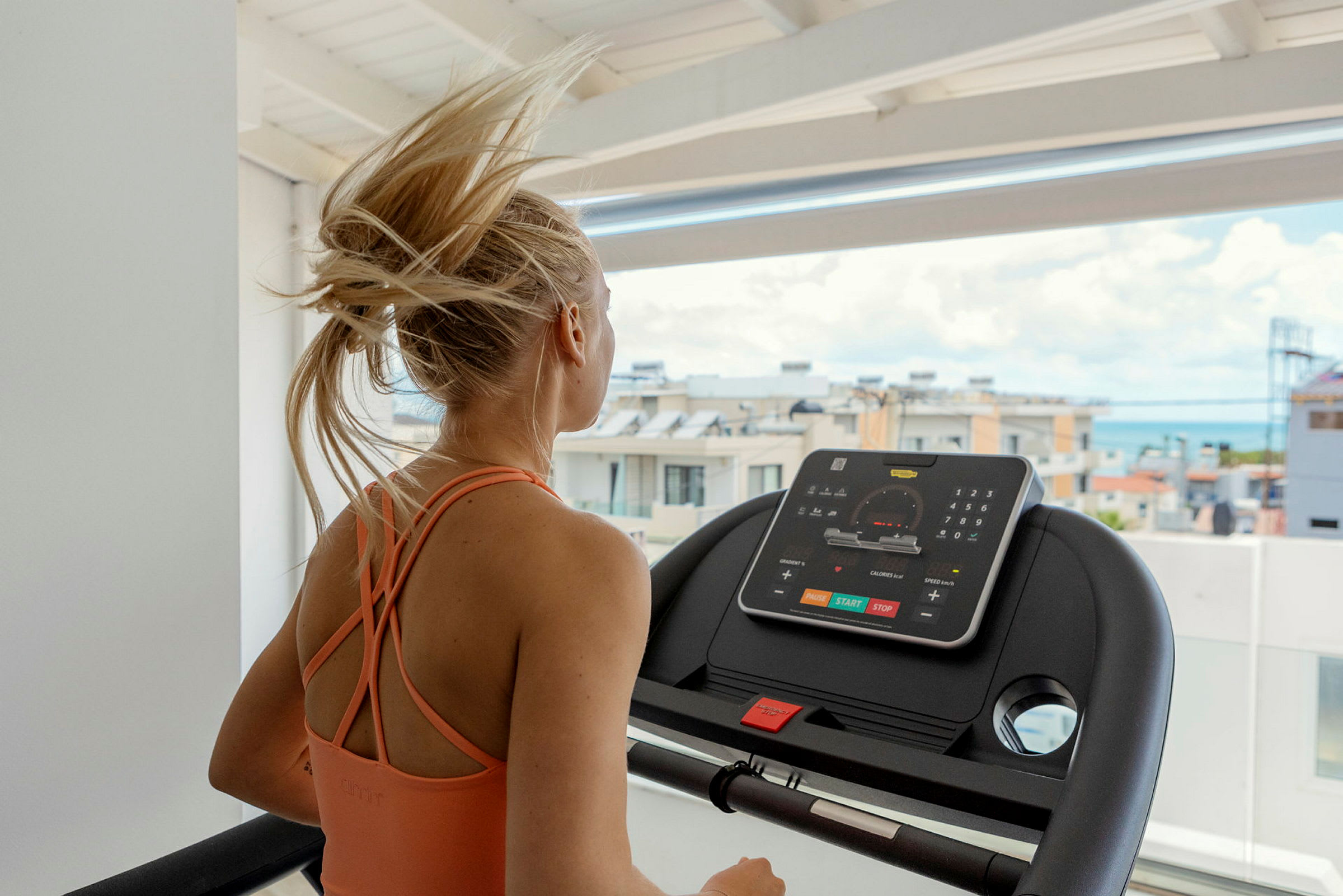Blond kvinna i sportkläder springer på löpband. (AI-genererad text)
