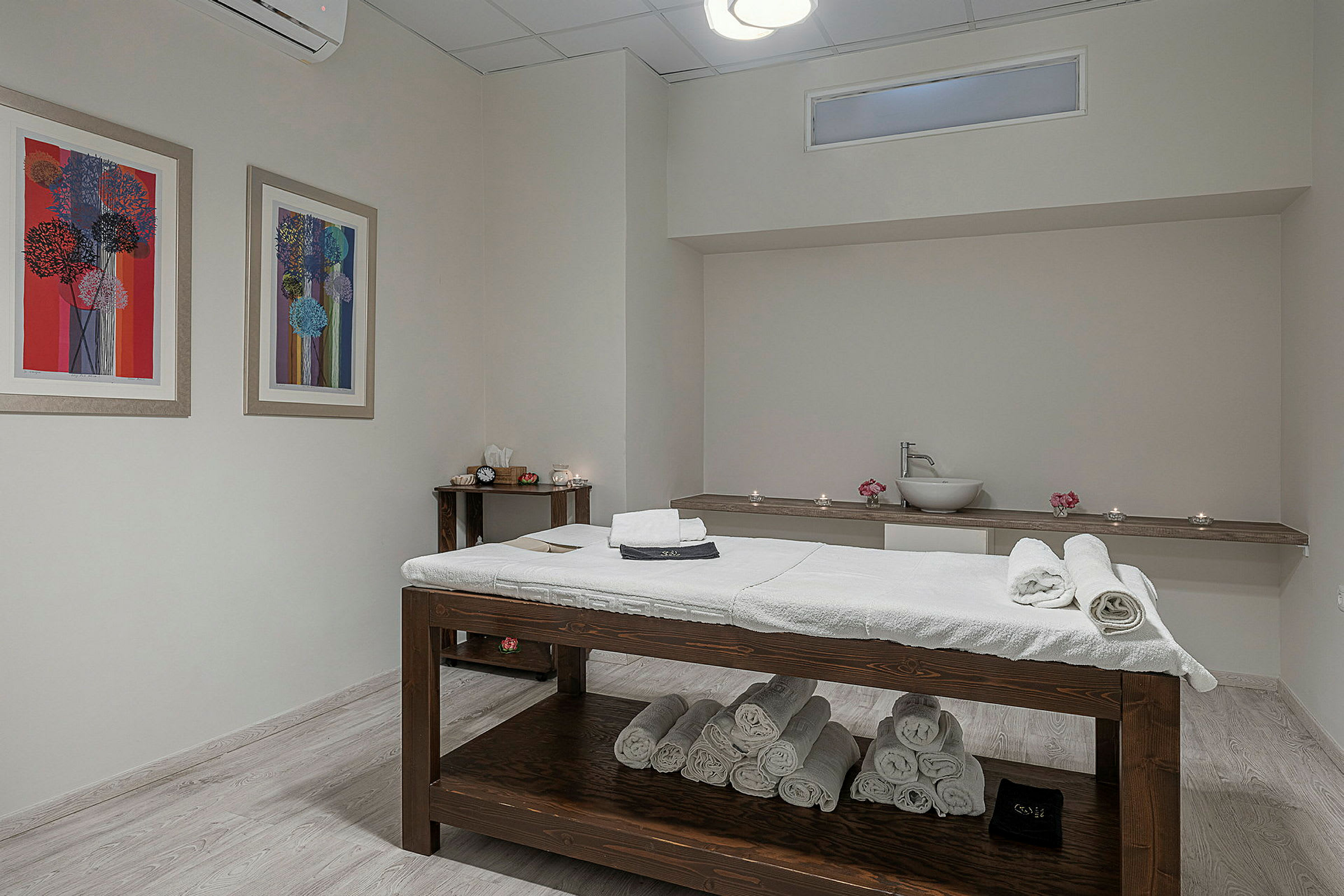 Ett rum med en massagebänk och prydlig uppsättning av handdukar. (AI-genererad text)