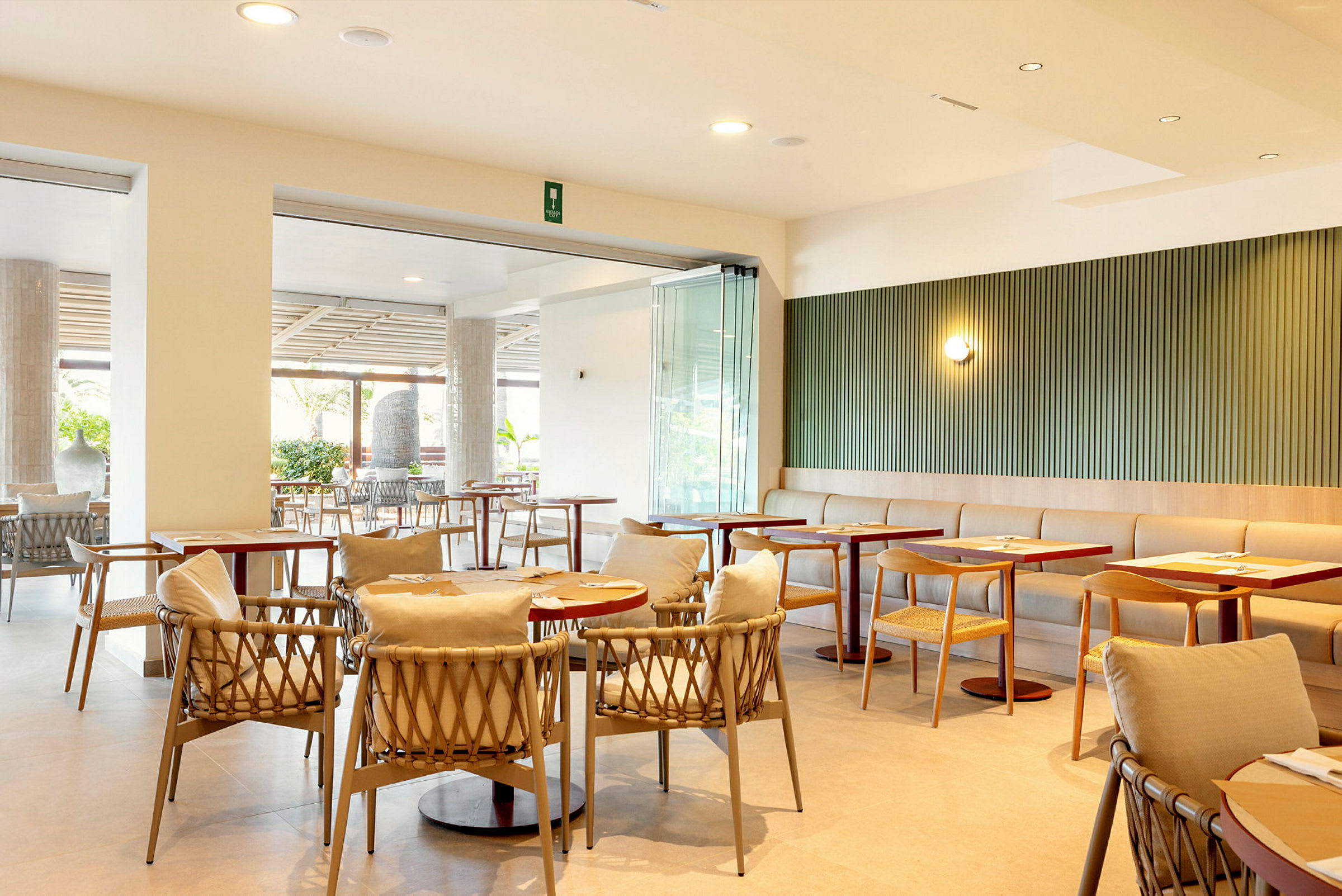 En modern restaurang med bord och stolar samt ljusa inredningsdetaljer. (AI-genererad text)