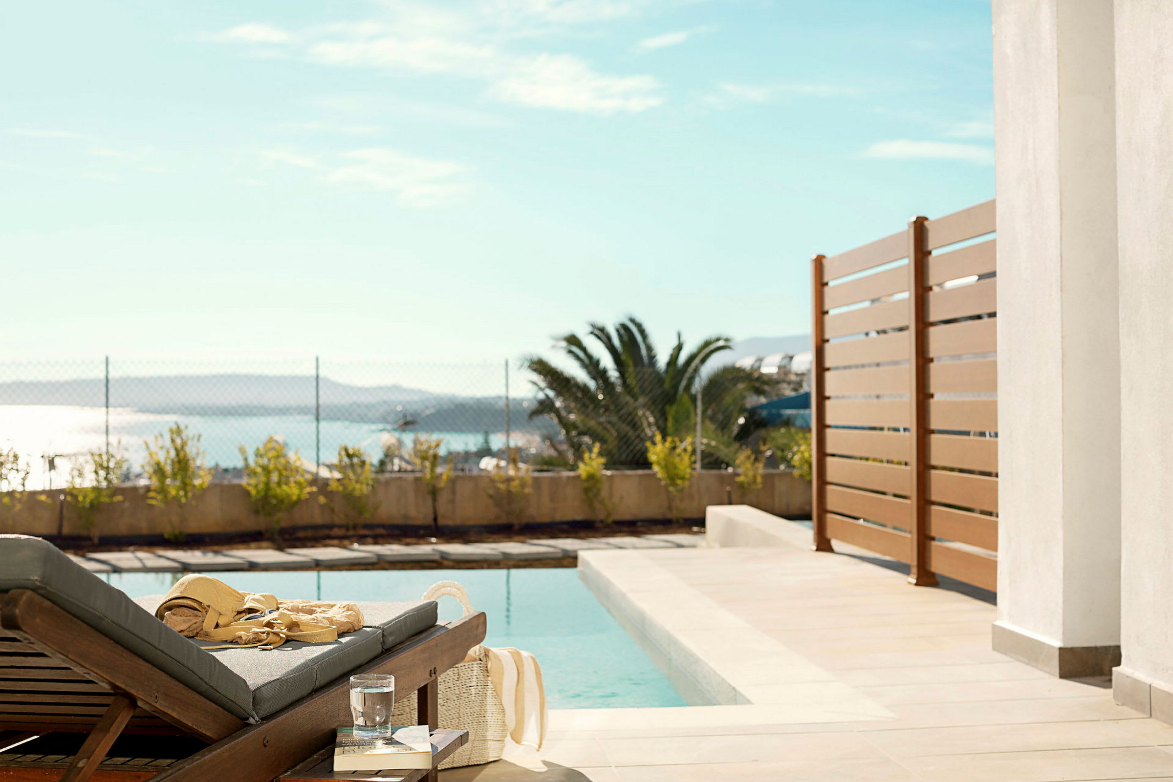 Solstol vid en pool med utsikt mot havet. (AI-genererad text)