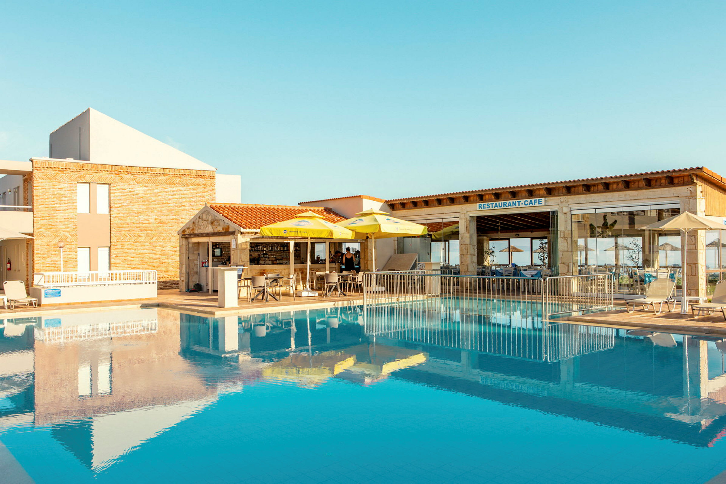 Hotellets poolområde med restaurang och café. (AI-genererad text)