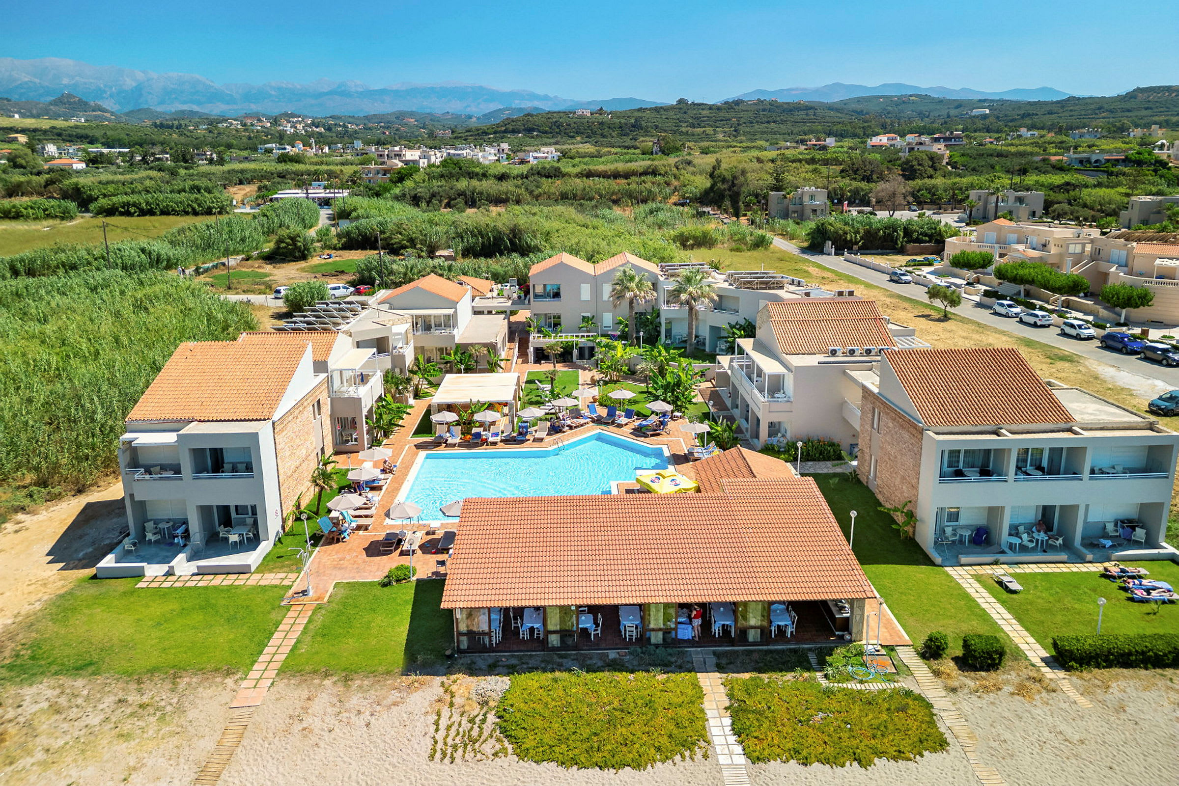Bild av en resort med pool, omgiven av gröna landskap och byggnader. (AI-genererad text)