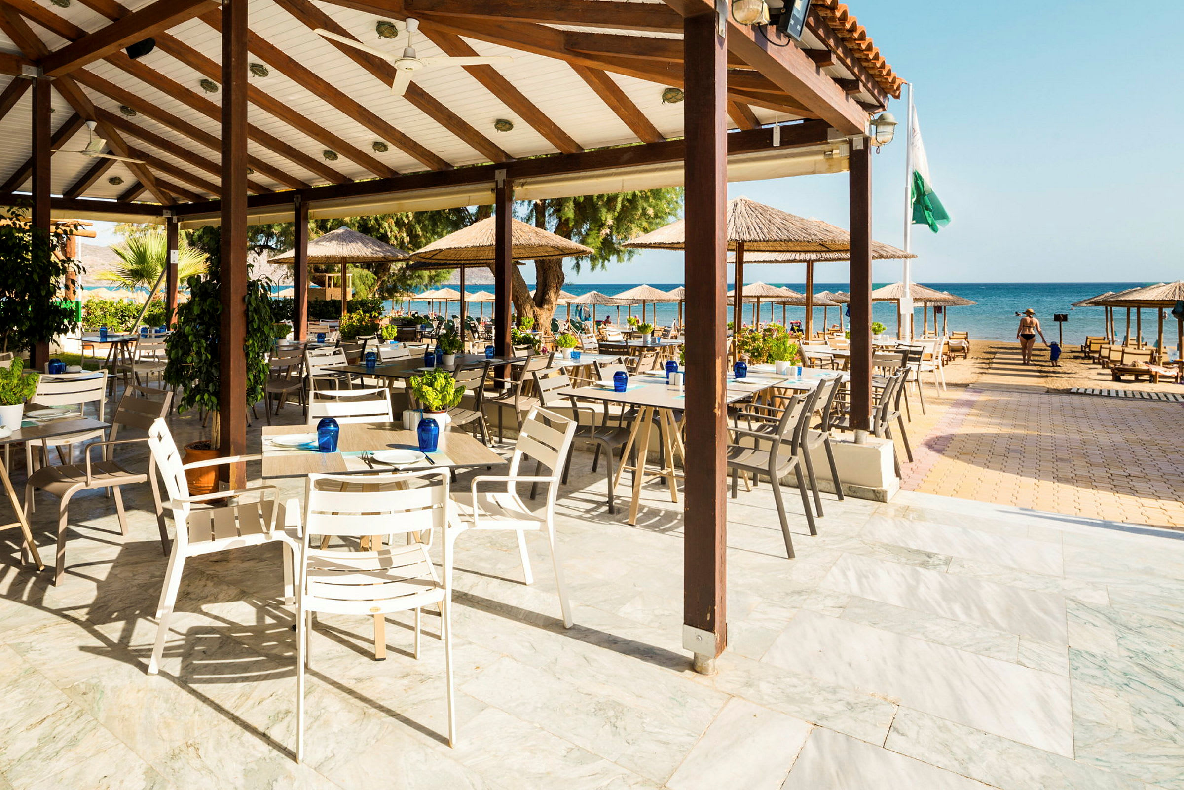 Öppen restaurang med utsikt mot stranden och havet. (AI-genererad text)