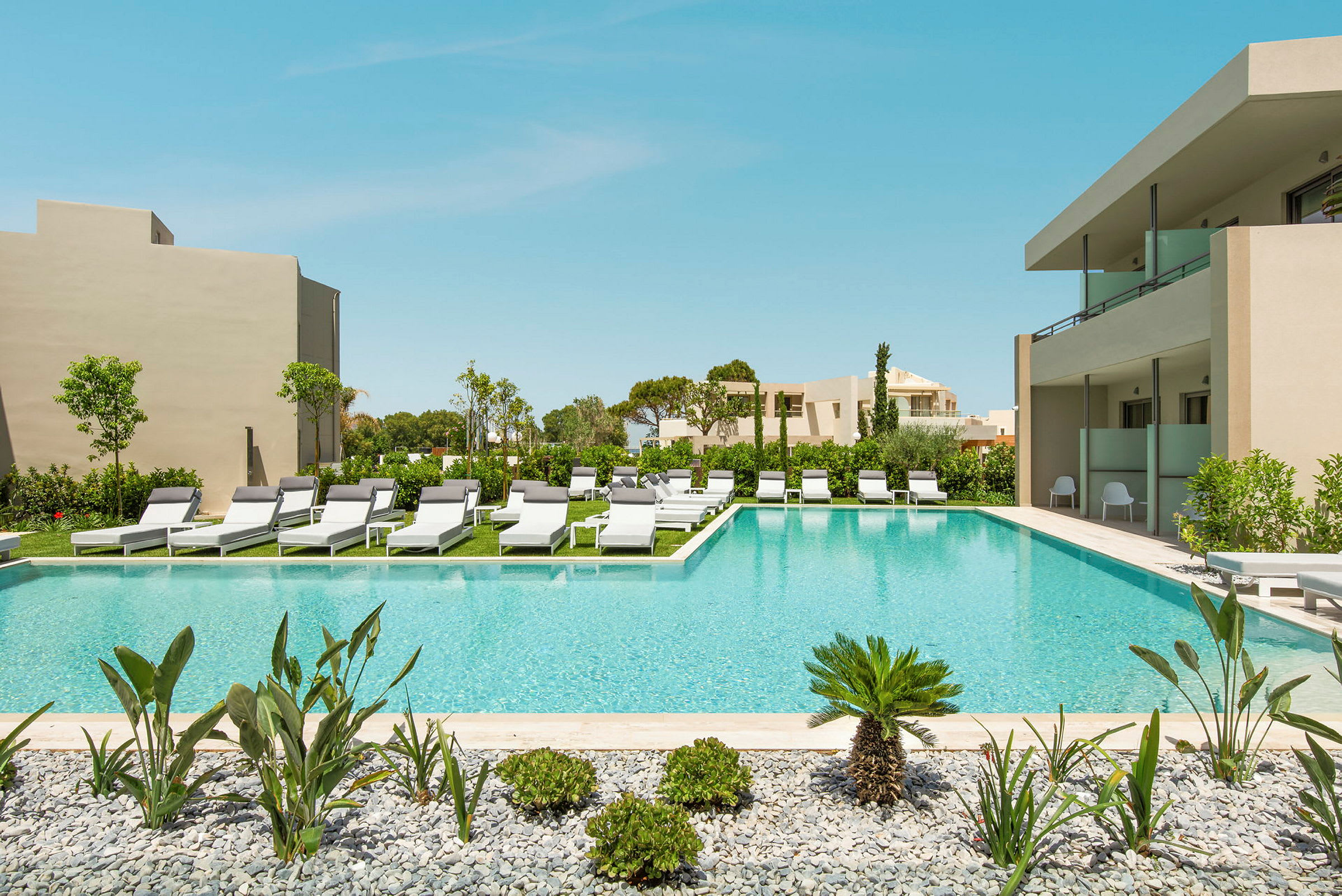 Pool med solstolar och omgivande grönska. (AI-genererad text)