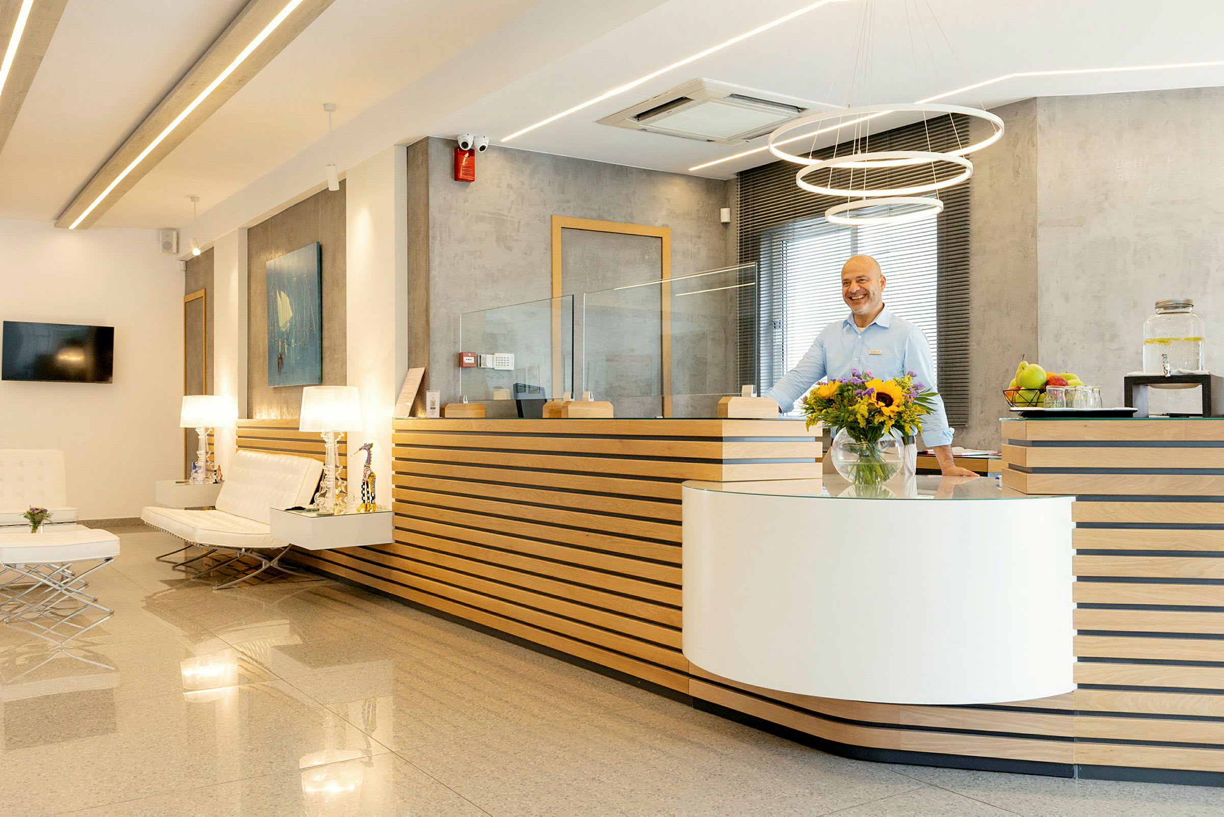 Hotellreception med modern inredning, blommor och personal vid disken. (AI-genererad text)