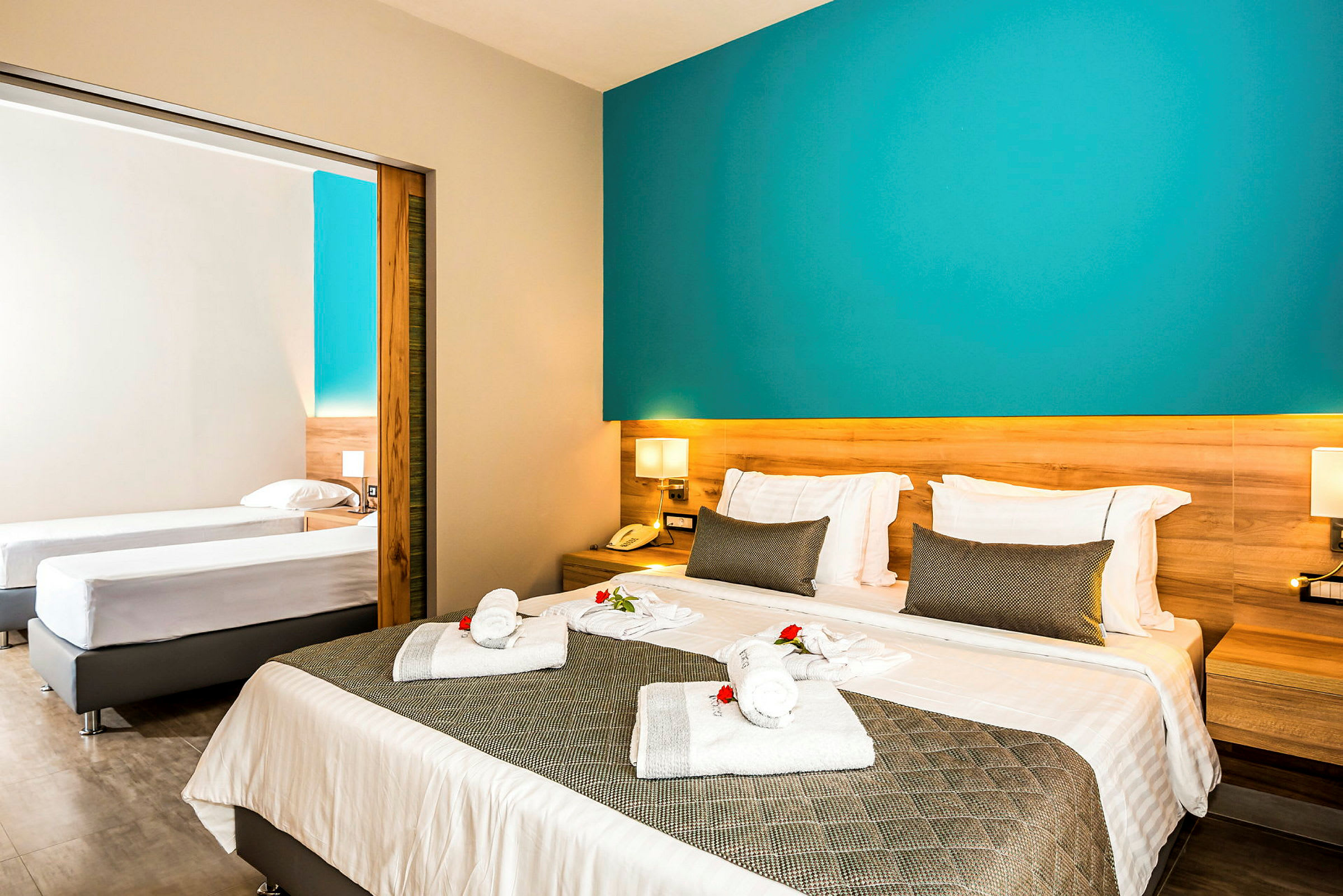Hotellrum med dubbelsäng och två enkelsängar. (AI-genererad text)
