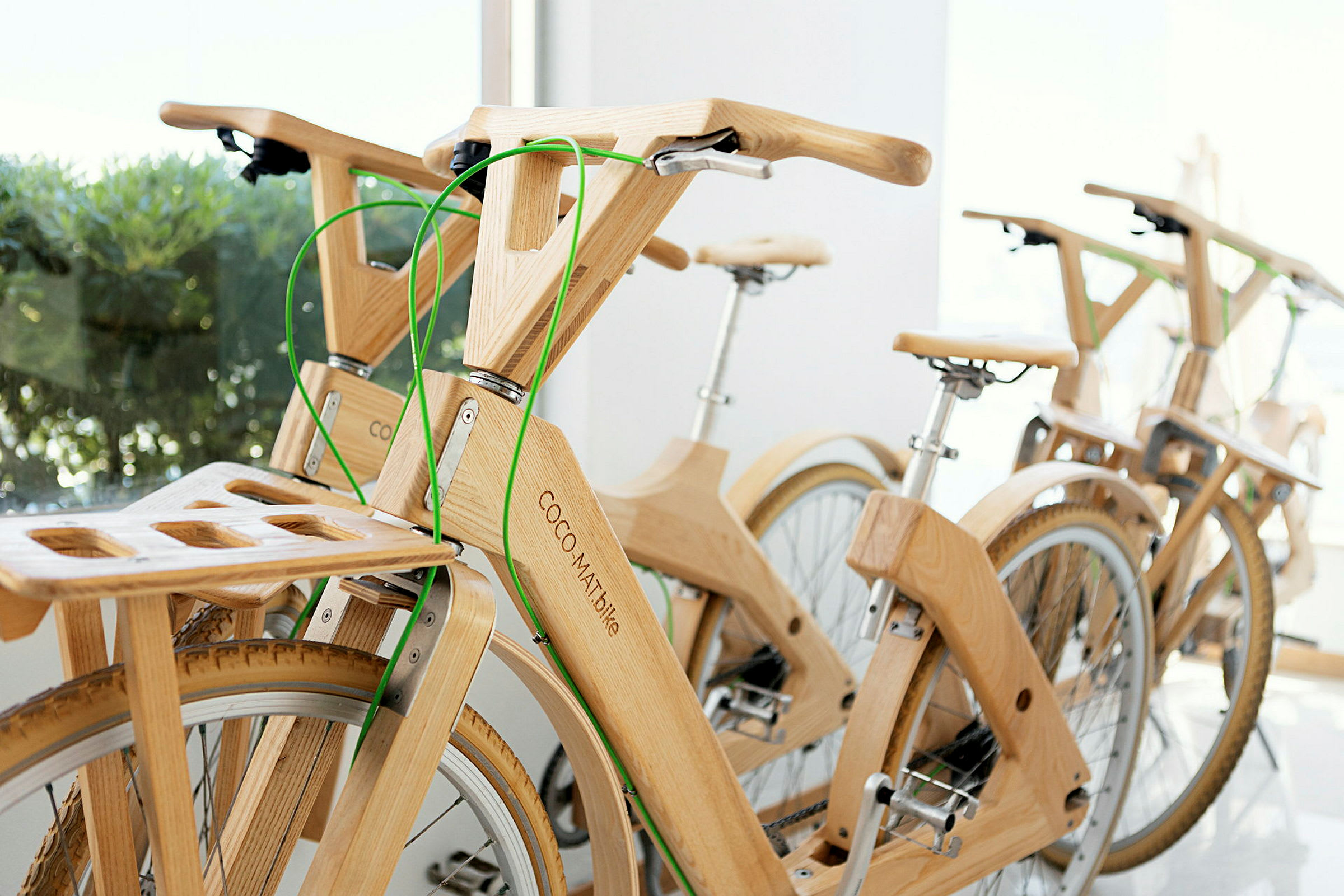 Träcyklar med gröna bromskablar på rad. (AI-genererad text)