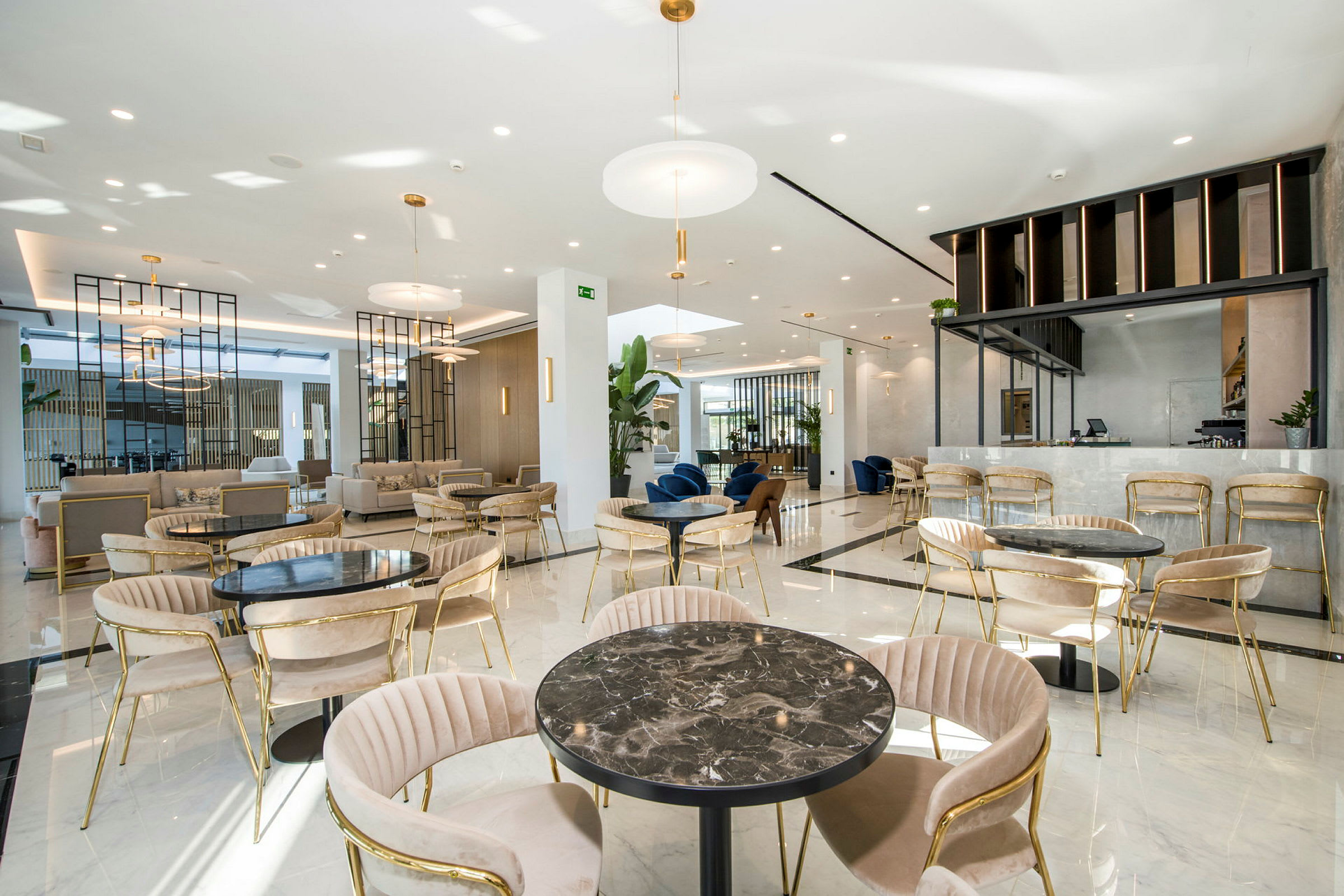 En rymlig lounge med sittgrupper och ett modernt inrett café. (AI-genererad text)
