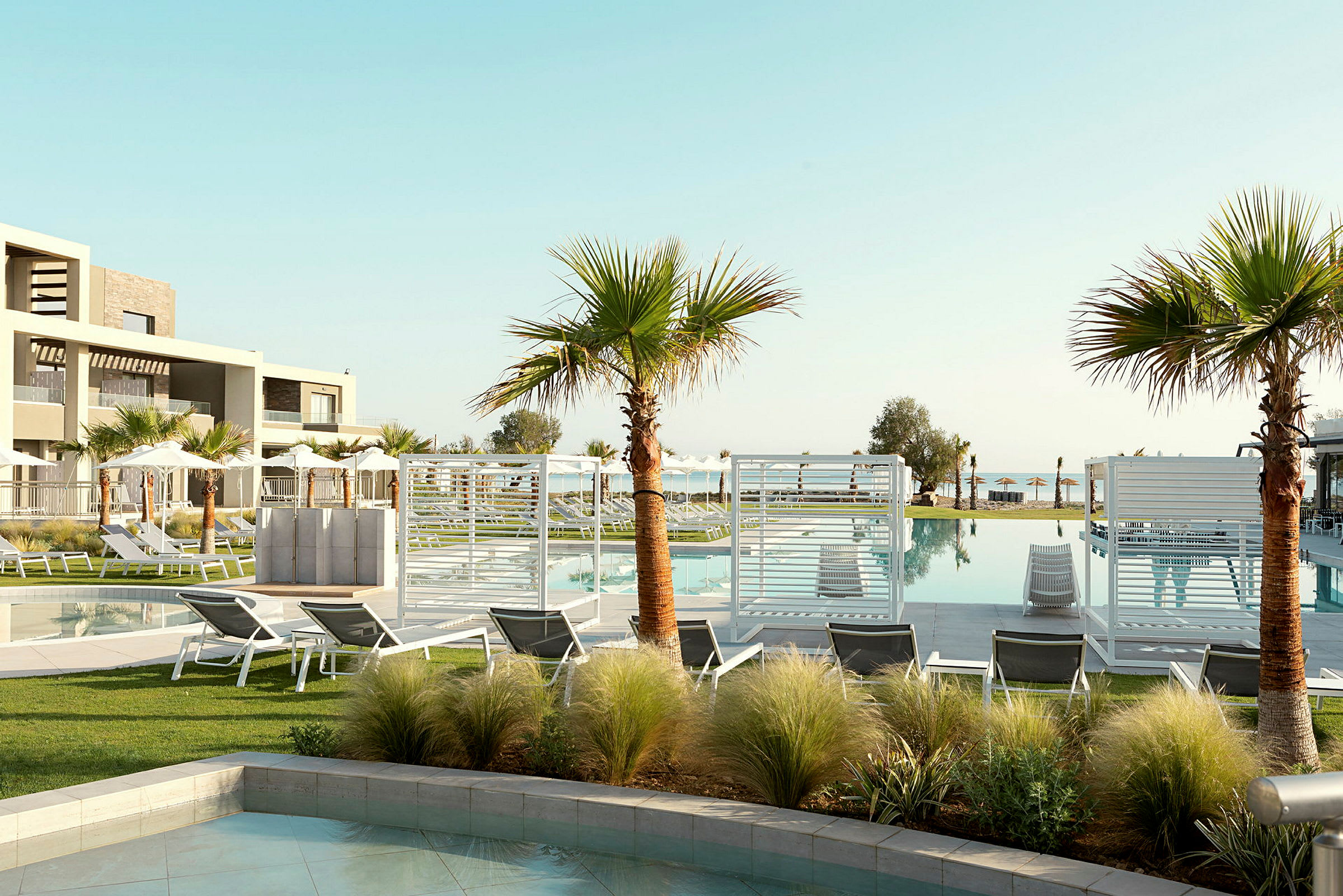 Hotellområde med pool, solstolar och palmer. (AI-genererad text)