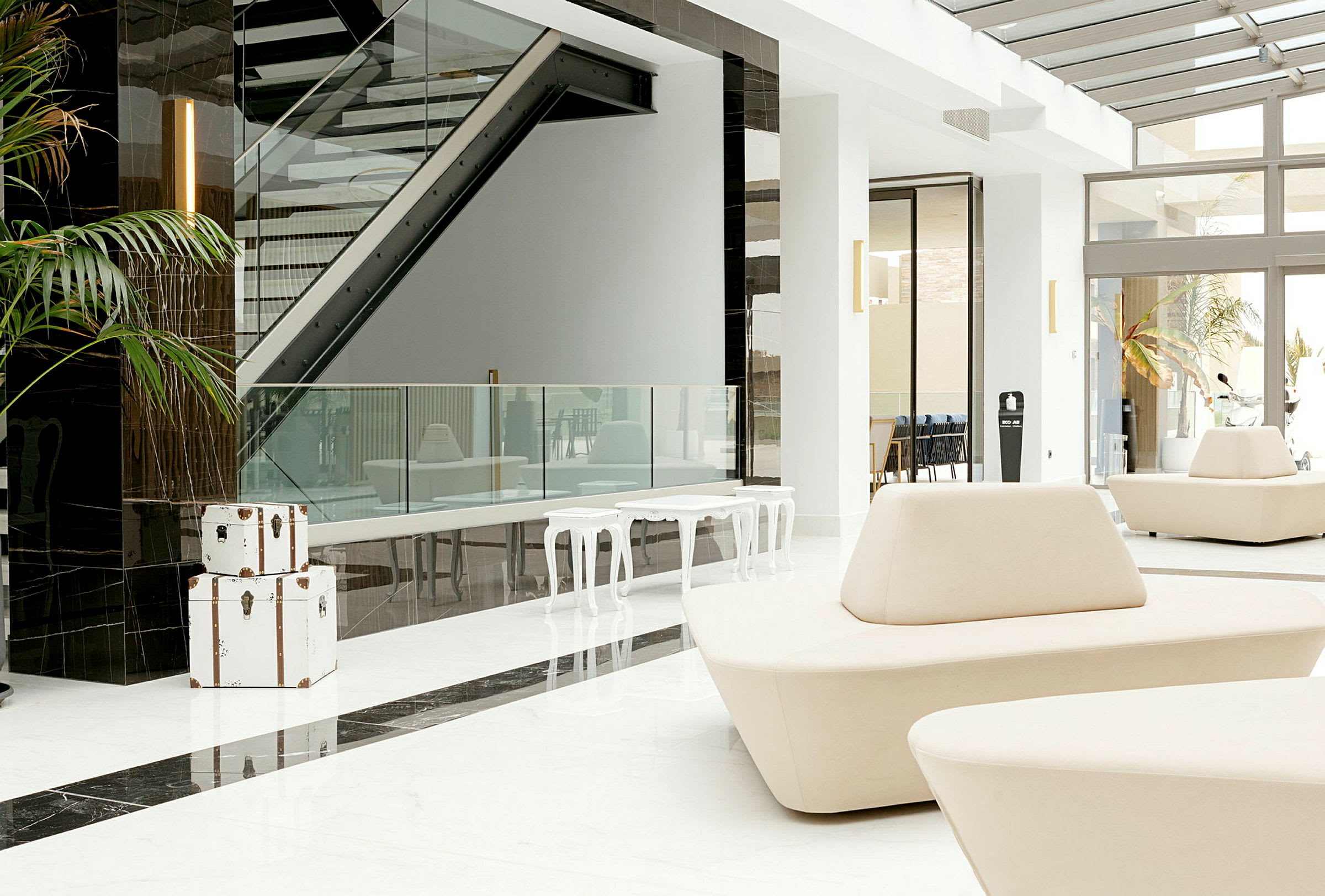 Ljus och modern hotellobby med vita möbler och glasdetaljer. (AI-genererad text)