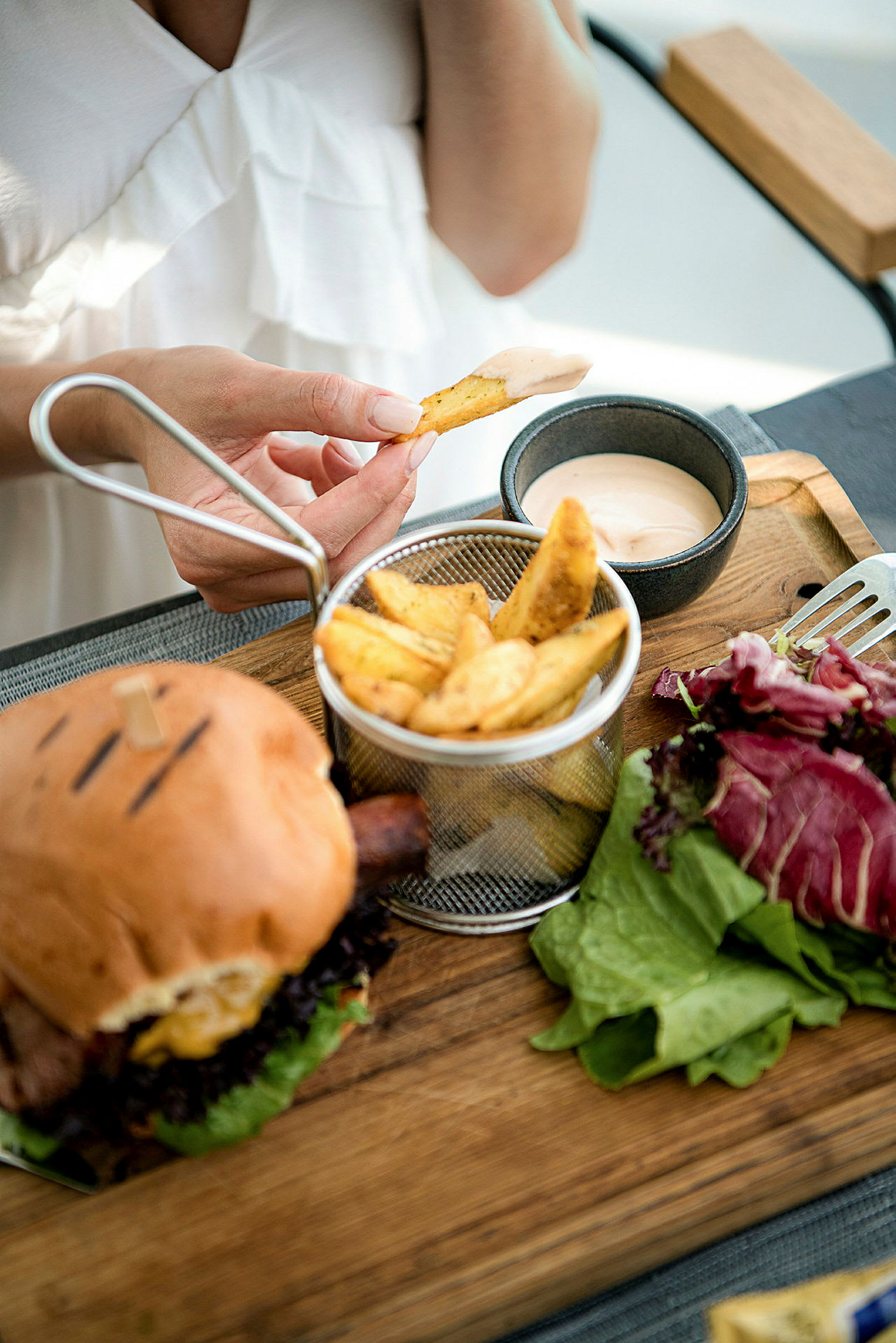 En person dippar ett pommes frites i en skål med sås. (AI-genererad text)