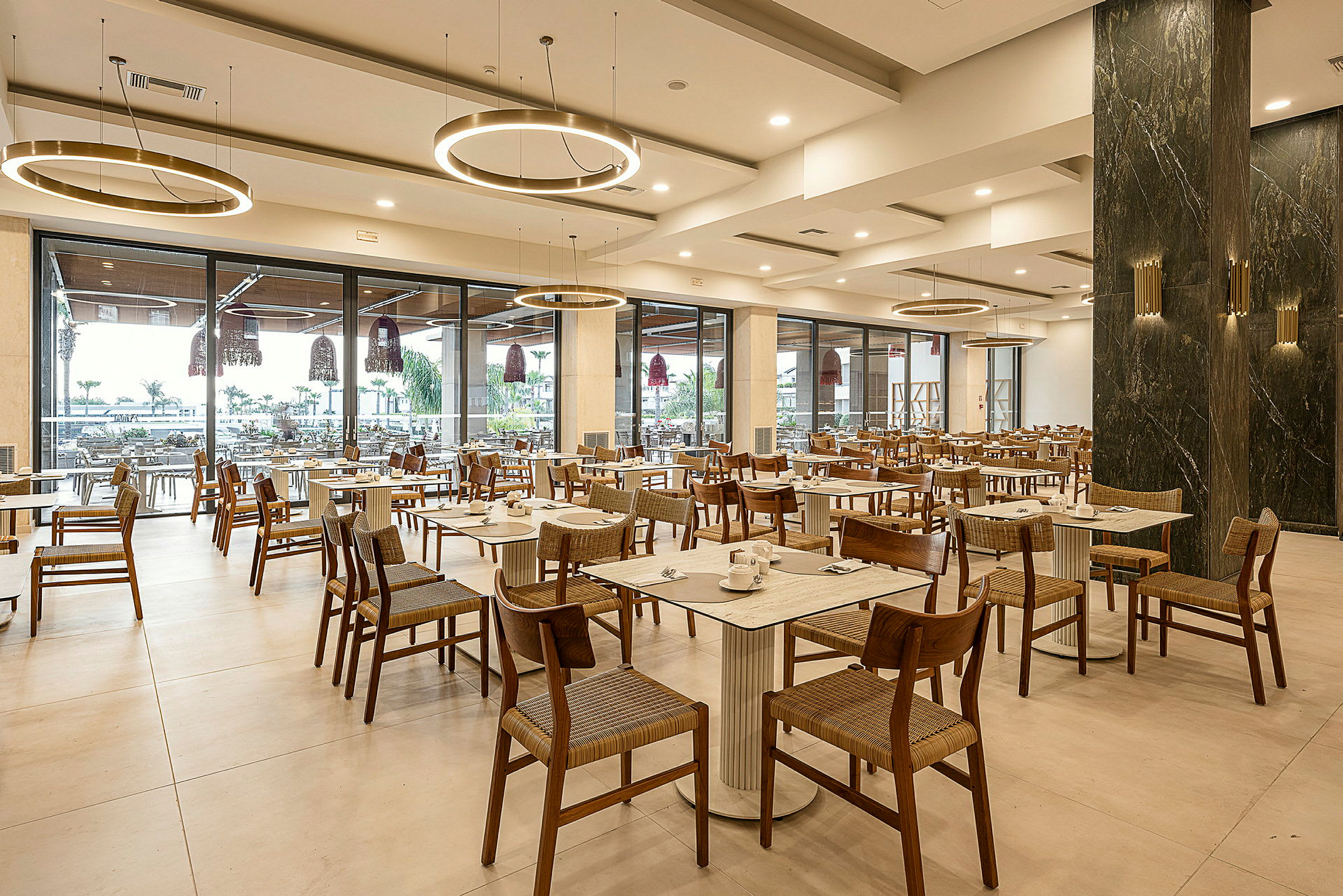 En restaurang med moderna möbler och glasväggar som vetter mot utsidan. (AI-genererad text)