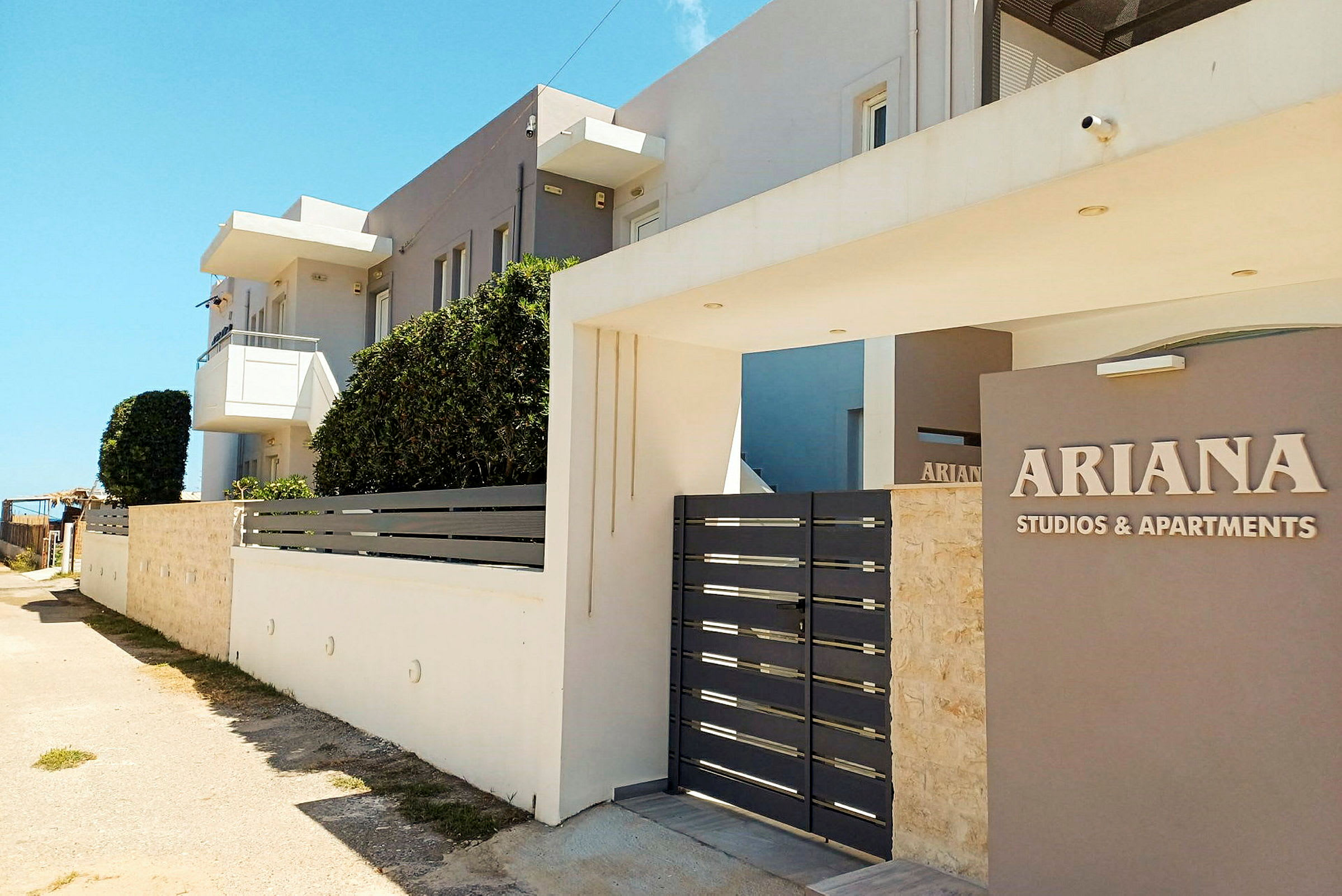 Utanför byggnaden Ariana Studios & Apartments. (AI-genererad text)
