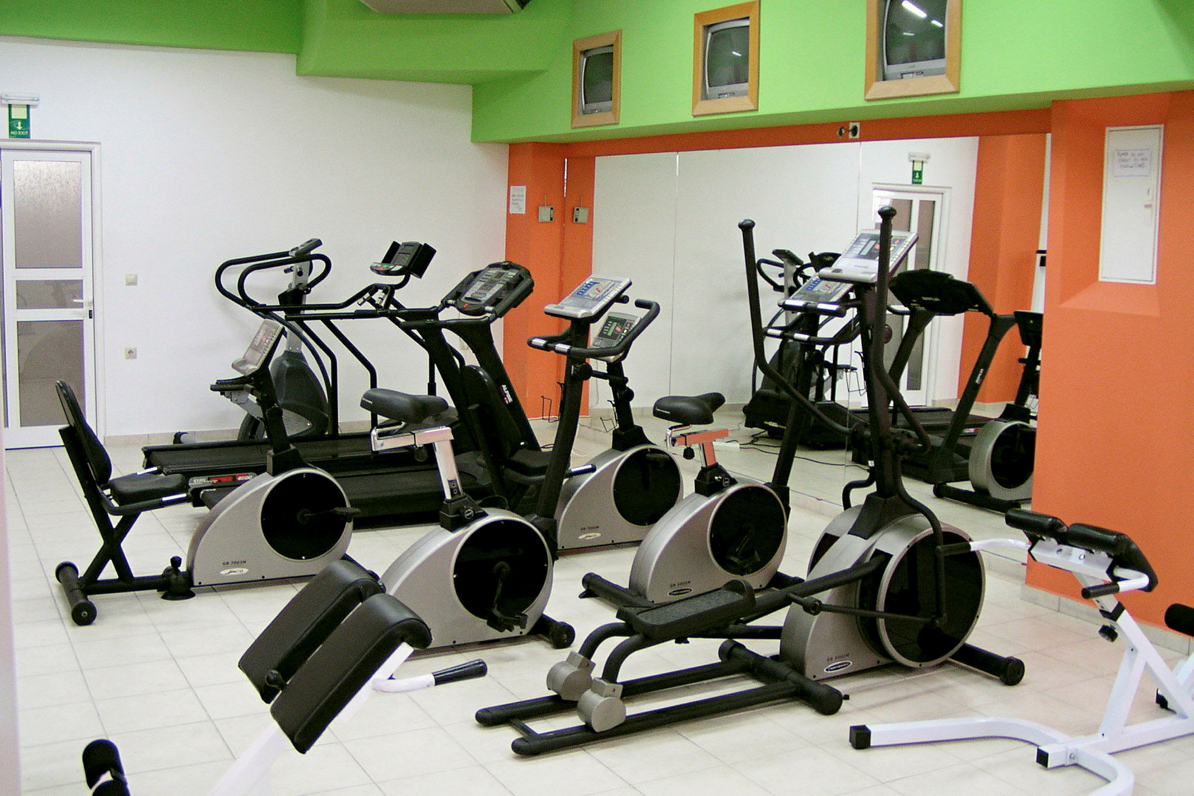 Gym med träningsmaskiner inklusive motionscyklar, löpband och andra konditionsmaskiner. (AI-genererad text)