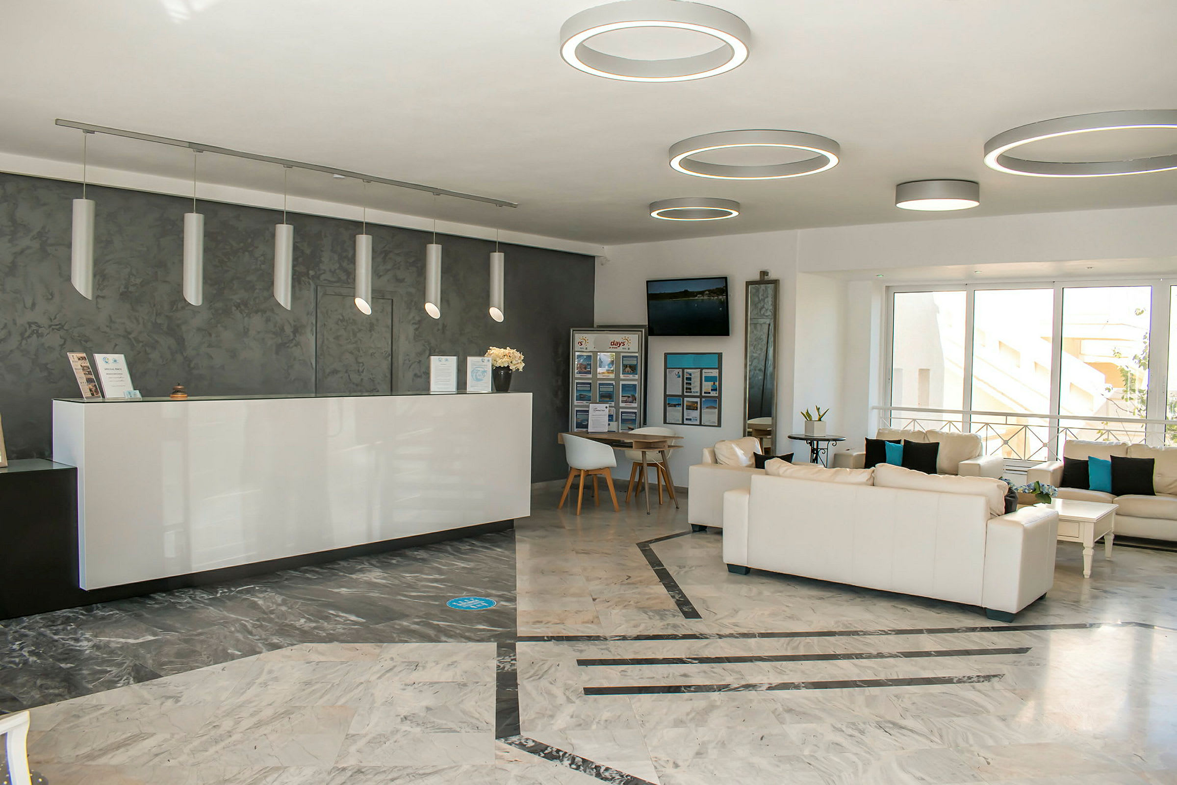 Ett ljust och modernt inrett receptionsområde med soffgrupper och en reception. (AI-genererad text)