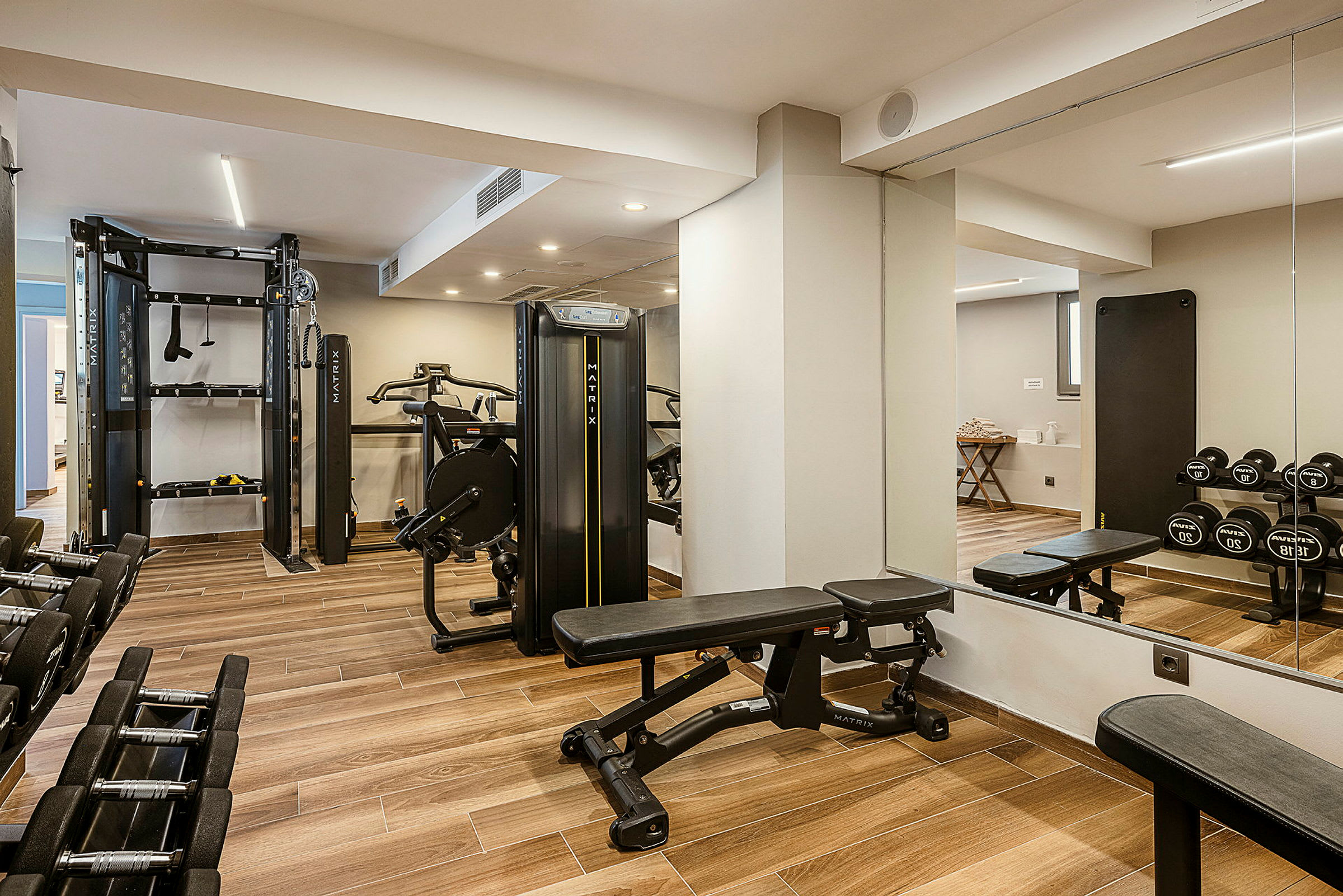 Ett gym med träningsmaskiner, hantlar och en träningsbänk. (AI-genererad text)