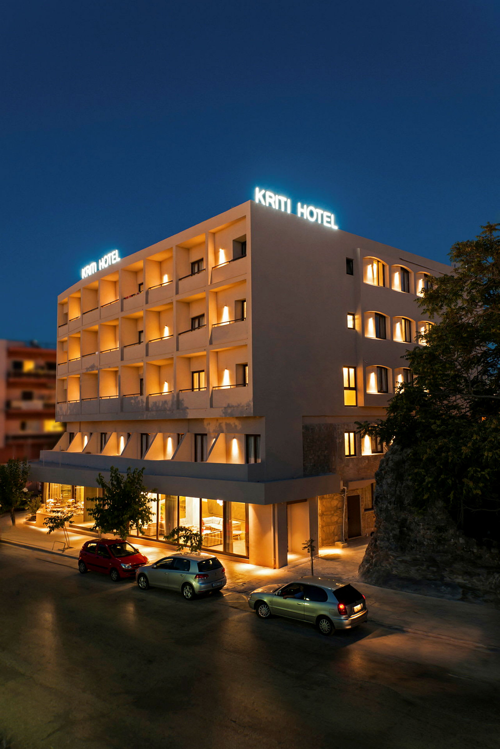 Hotellbyggnad vid nattid med belyst skylt och fasad. (AI-genererad text)