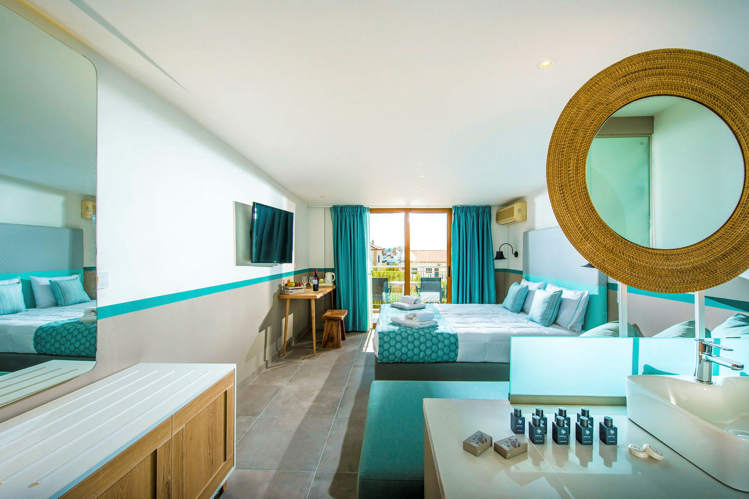 Ett modernt hotellrum med dubbelsäng, blå detaljer och ett stort fönster ut mot balkongen. (AI-genererad text)