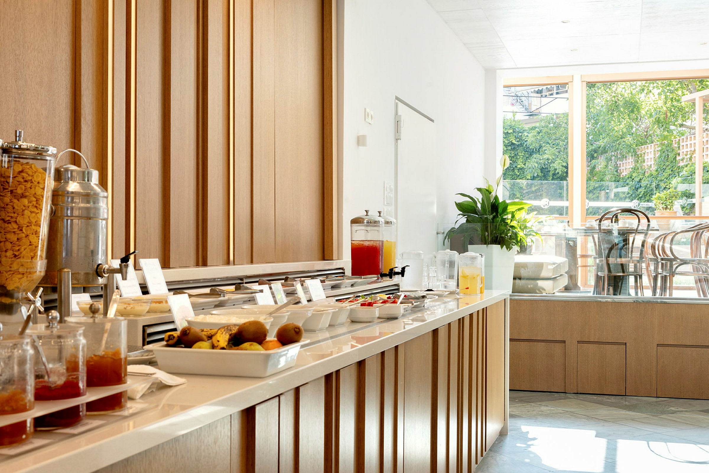 Frukostbuffé med olika alternativ och drycker, samt sittplatser i bakgrunden. (AI-genererad text)