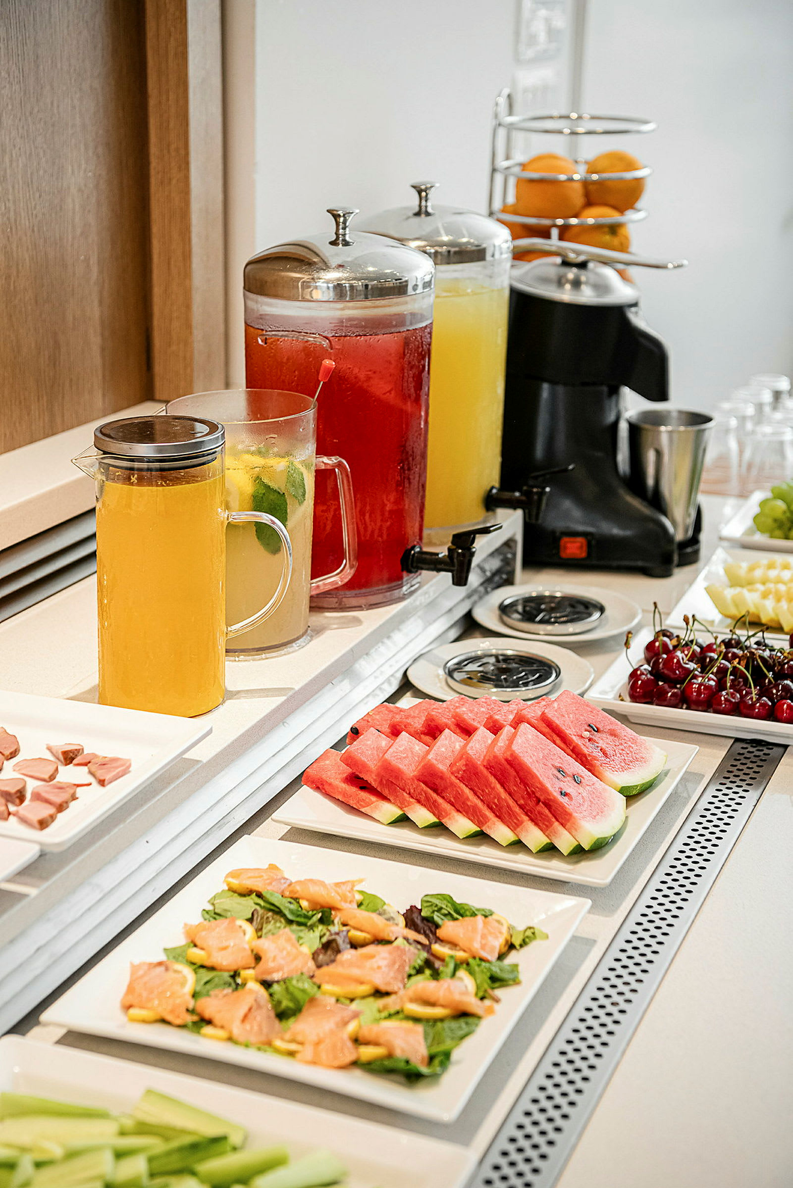 Buffé med fruktskivor, salladsrätter och karaffer med dryck. (AI-genererad text)