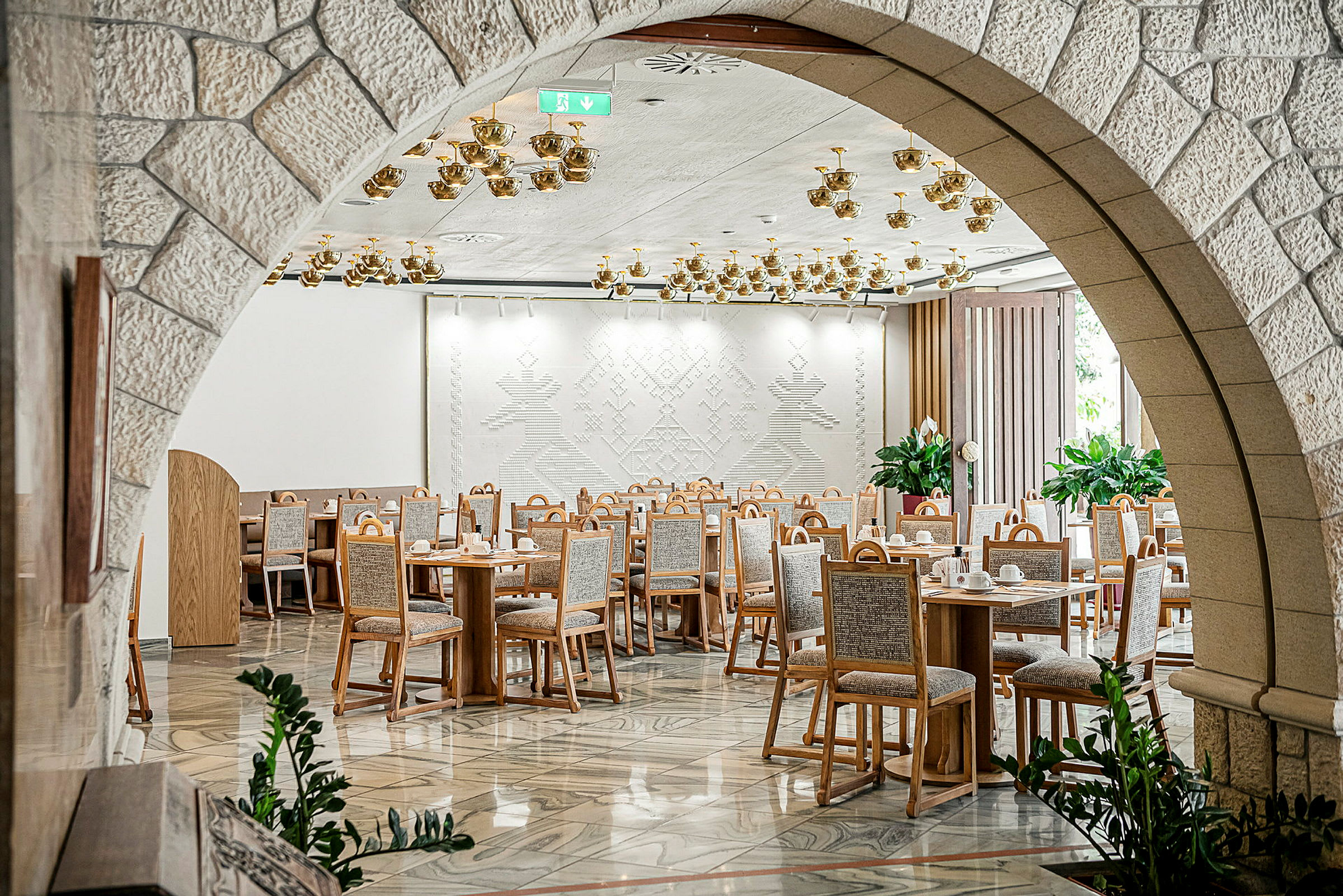 Restaurang med bord och stolar uppställda i ett dekorativt väntrum. (AI-genererad text)