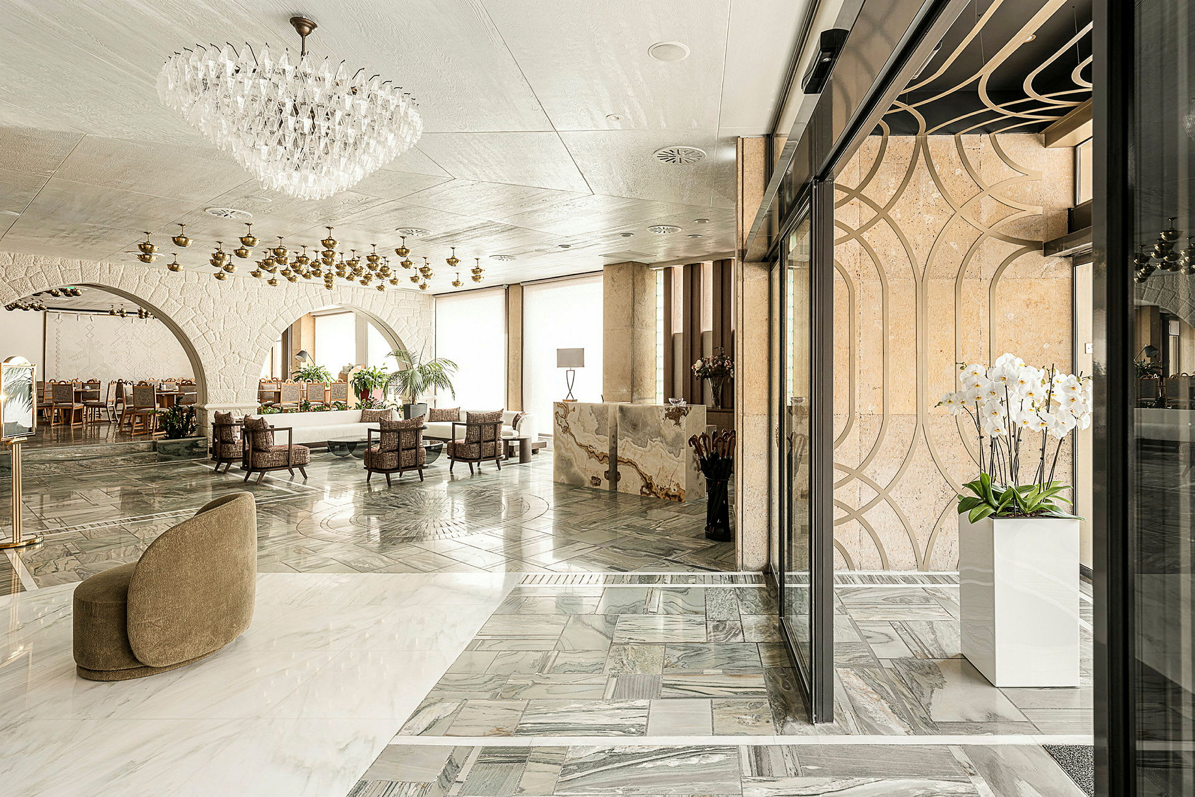 Elegant hotellobby med marmorgolv, kristallkrona och moderna möbler. (AI-genererad text)
