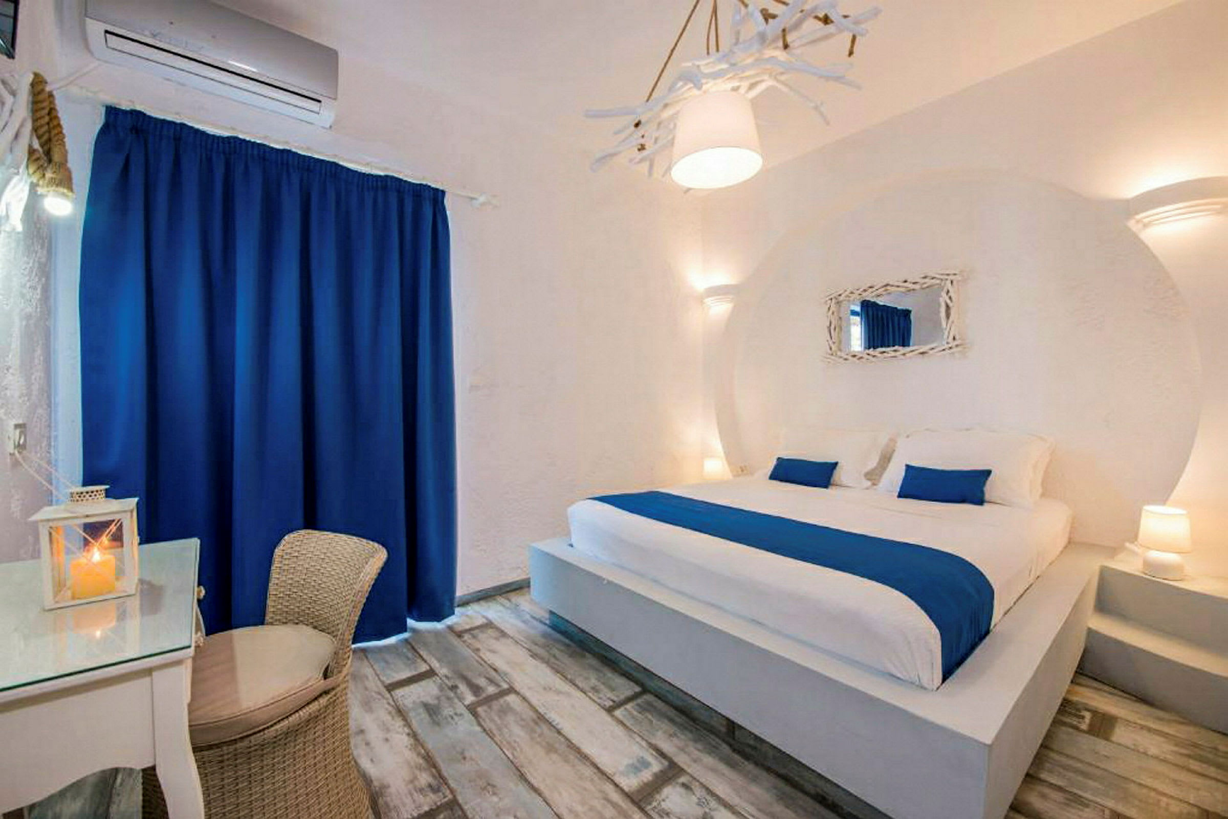 Ett hotellrum med en stor säng och blå och vita detaljer. (AI-genererad text)