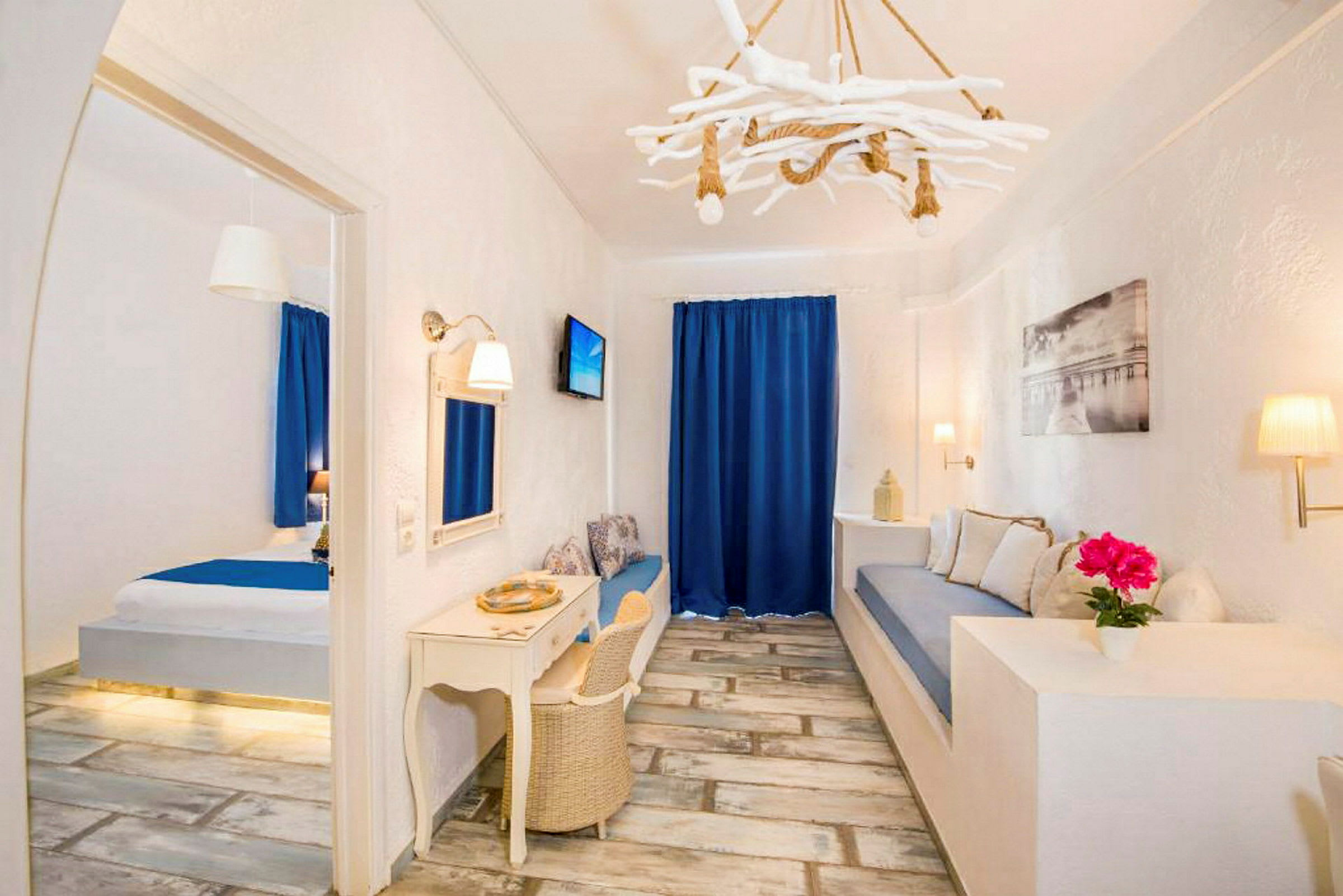 Ett hotellrum med vit inredning, blå detaljer och trämöbler. (AI-genererad text)